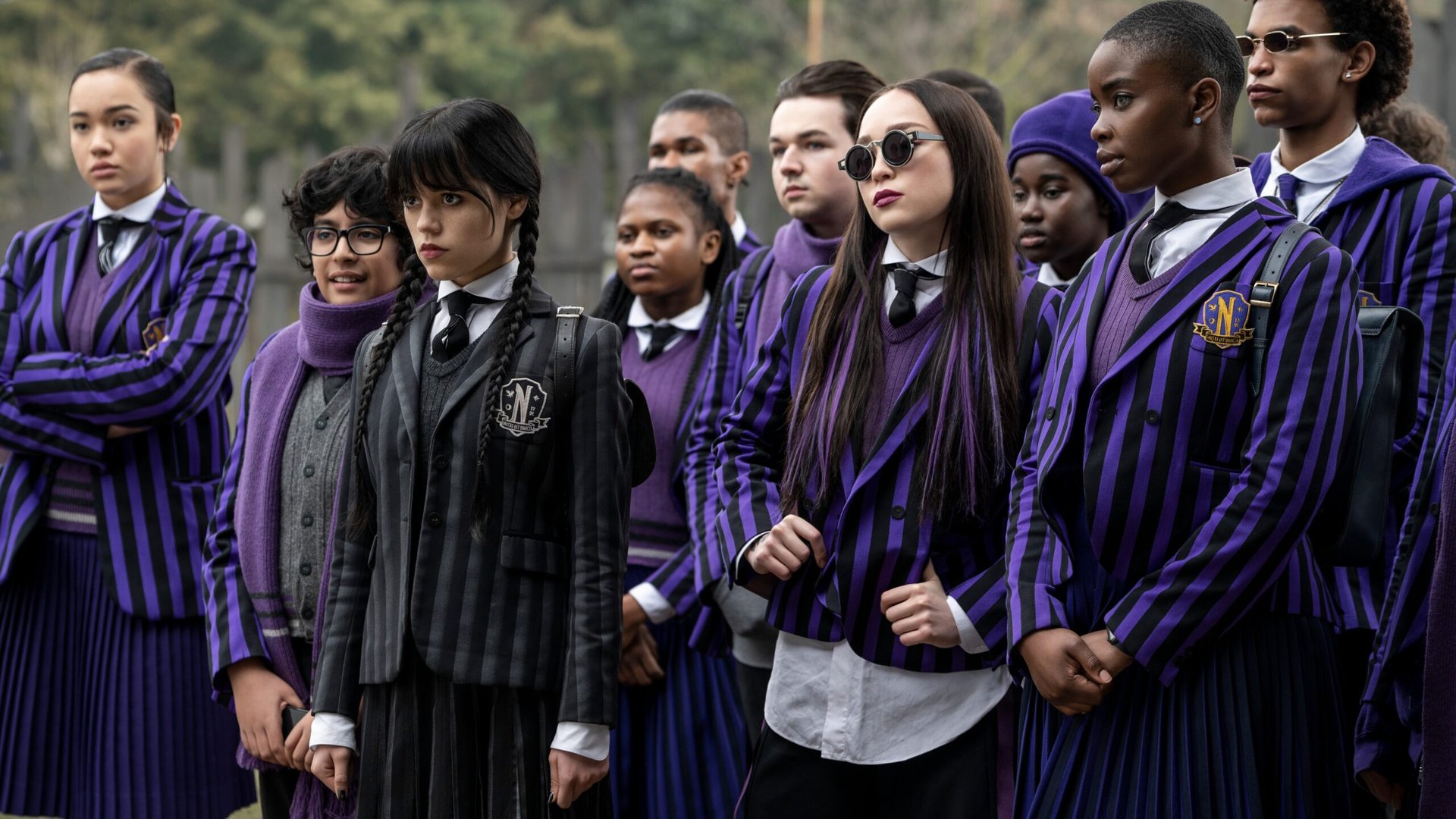 Wednesday Addams stands with a group of classmates in their school uniforms in Wednesday