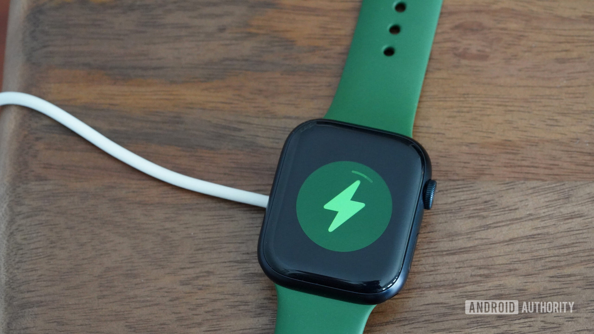 An Apple Watch Series 8 with ample battery life rests on its charger.