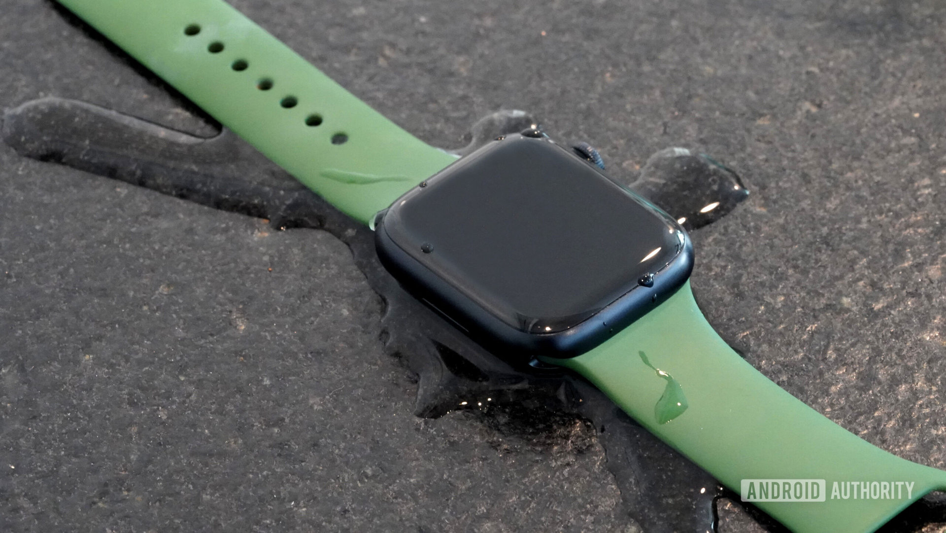 An Apple Watch Series 8 rests in a small puddle.
