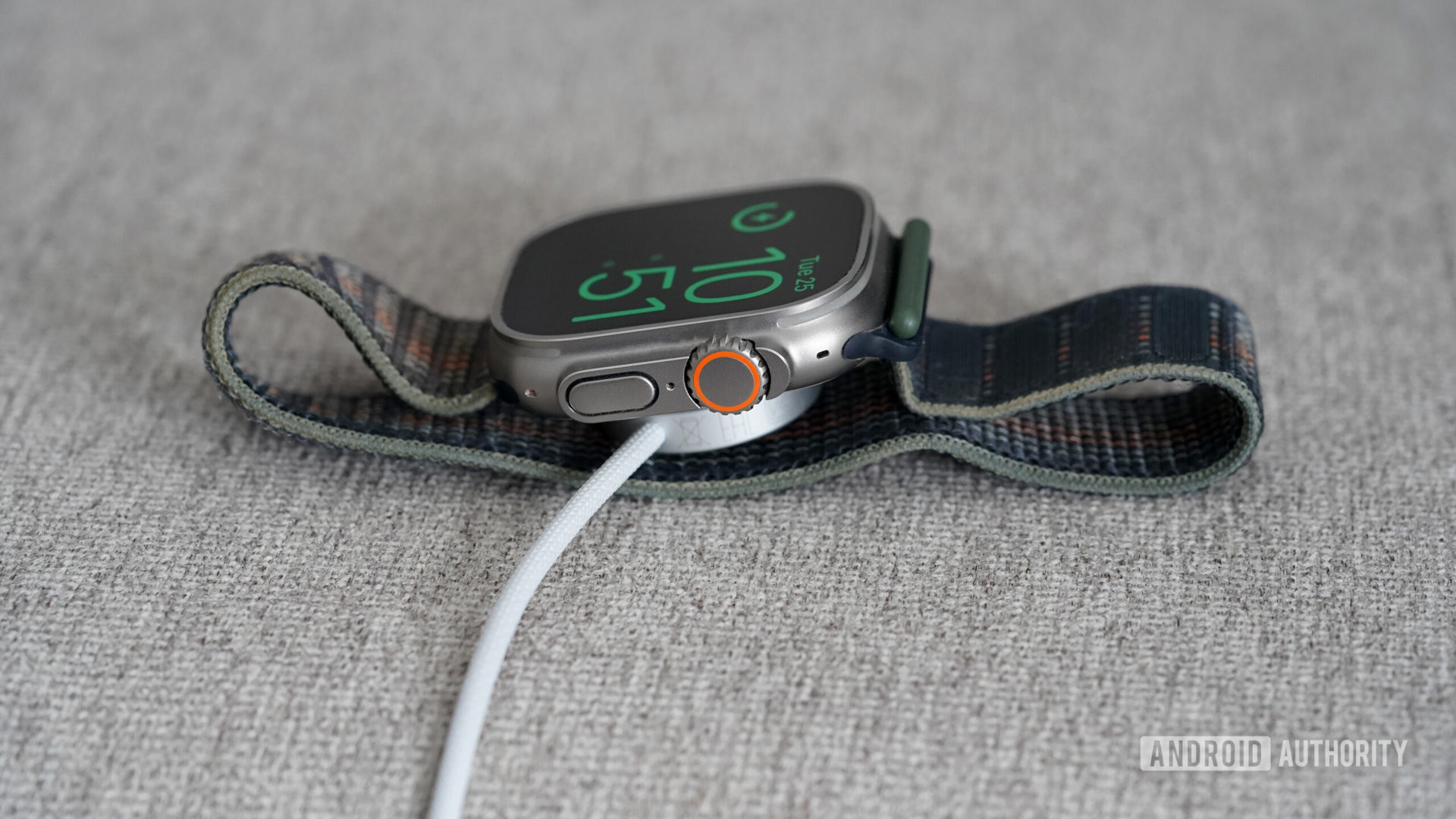 An Apple Watch Ultra charges on its proprietary magnetic charger.