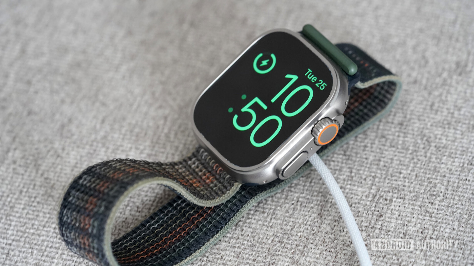 An Apple Watch Ultra rest on its magnetic charger.