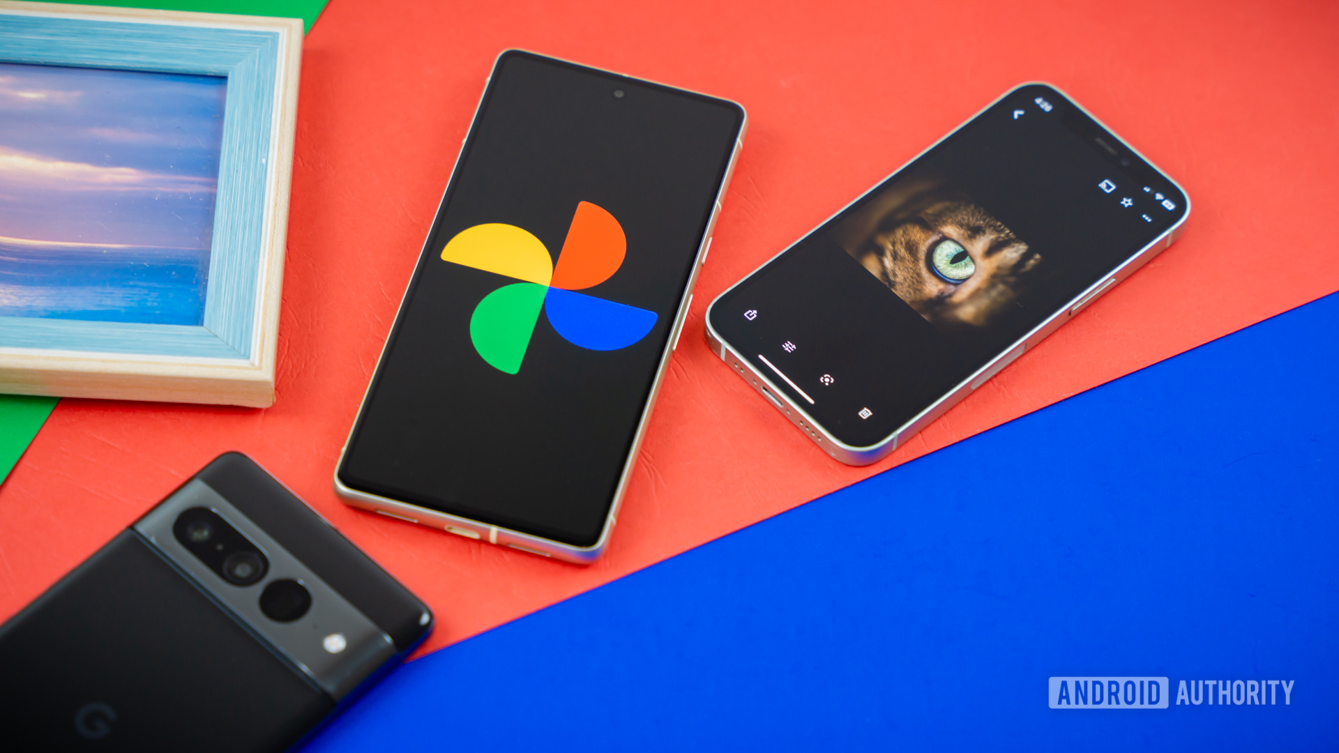 Google Photos logo on smartphone next to other devices and picture frame Stock photo 1