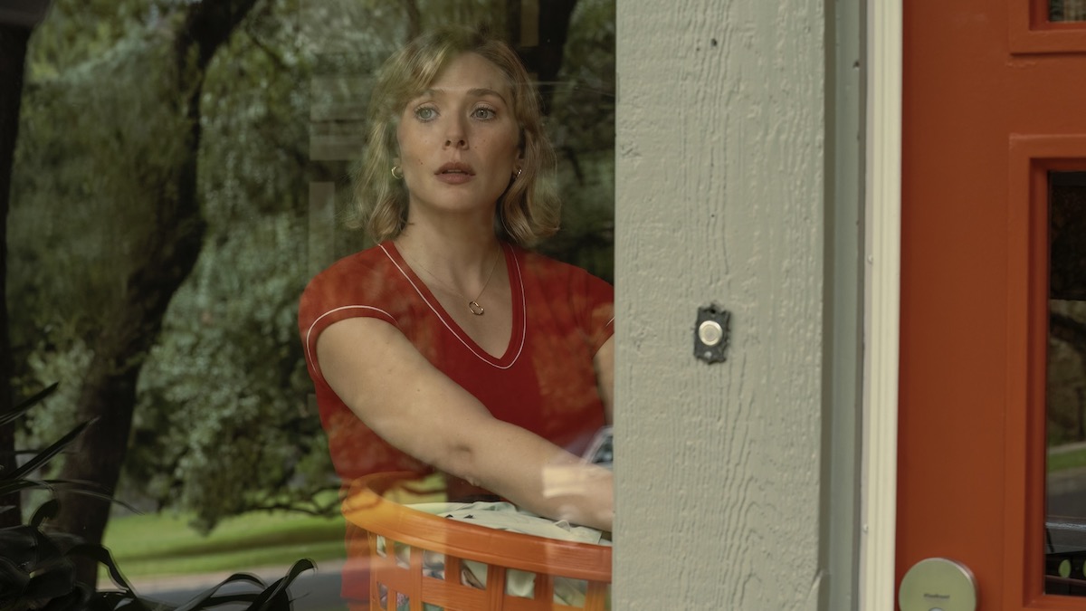 Elizabeth Olsen stands in a window holding laundry in Love and Death - best new streaming shows