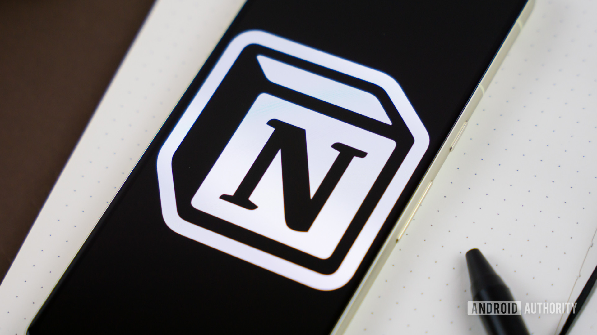Notion logo on smartphone next to other office products Stock photo 6