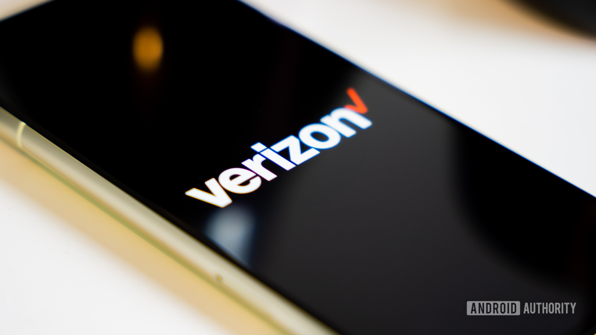 Verizon logo on smartphone laying on desk Stock photo 2