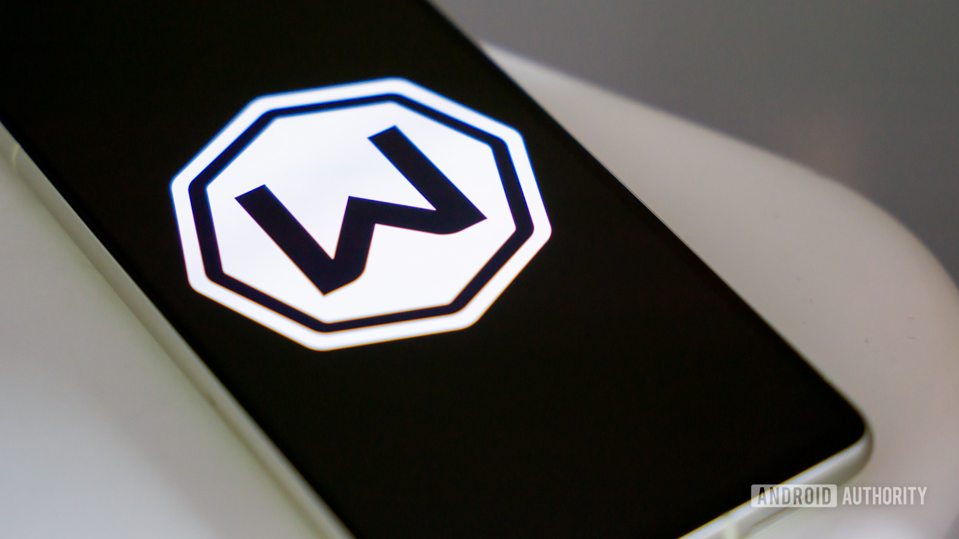 Windscribe logo on smartphone laying on desk Stock photo