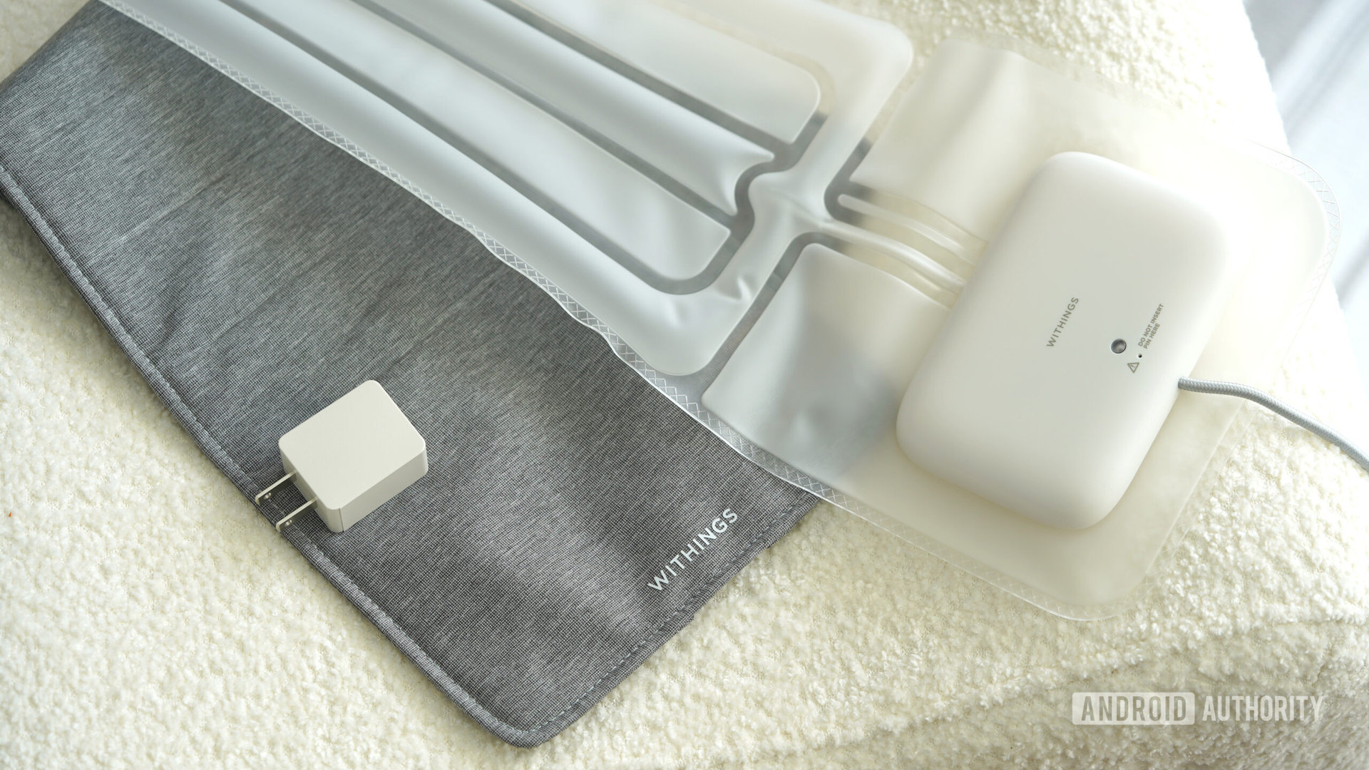 A Withing Sleep Tracking Mat rests alongside its fabric cover and power adapter.