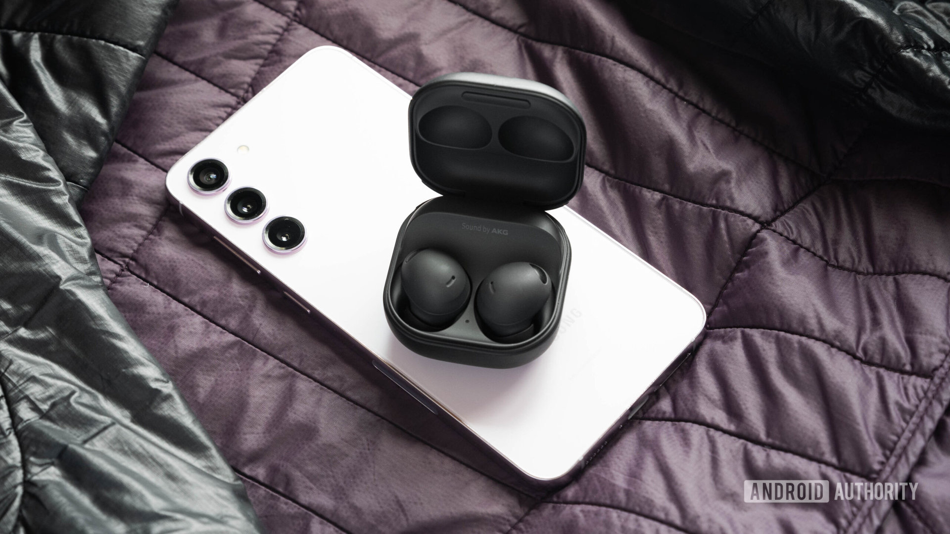 The samsung galaxy buds 2 pro earbuds and case on top of a Galaxy S23 Plus.
