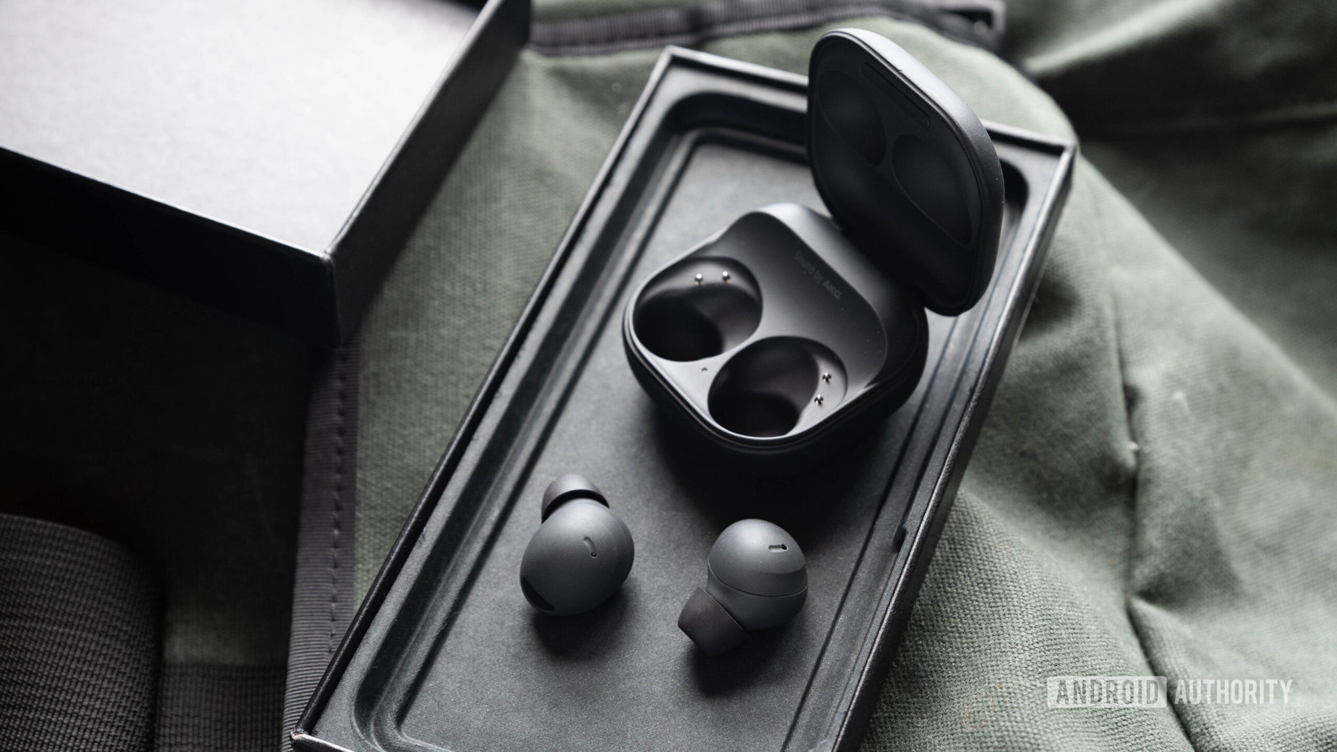 The samsung galaxy buds 2 pro earbuds outside of the open case.