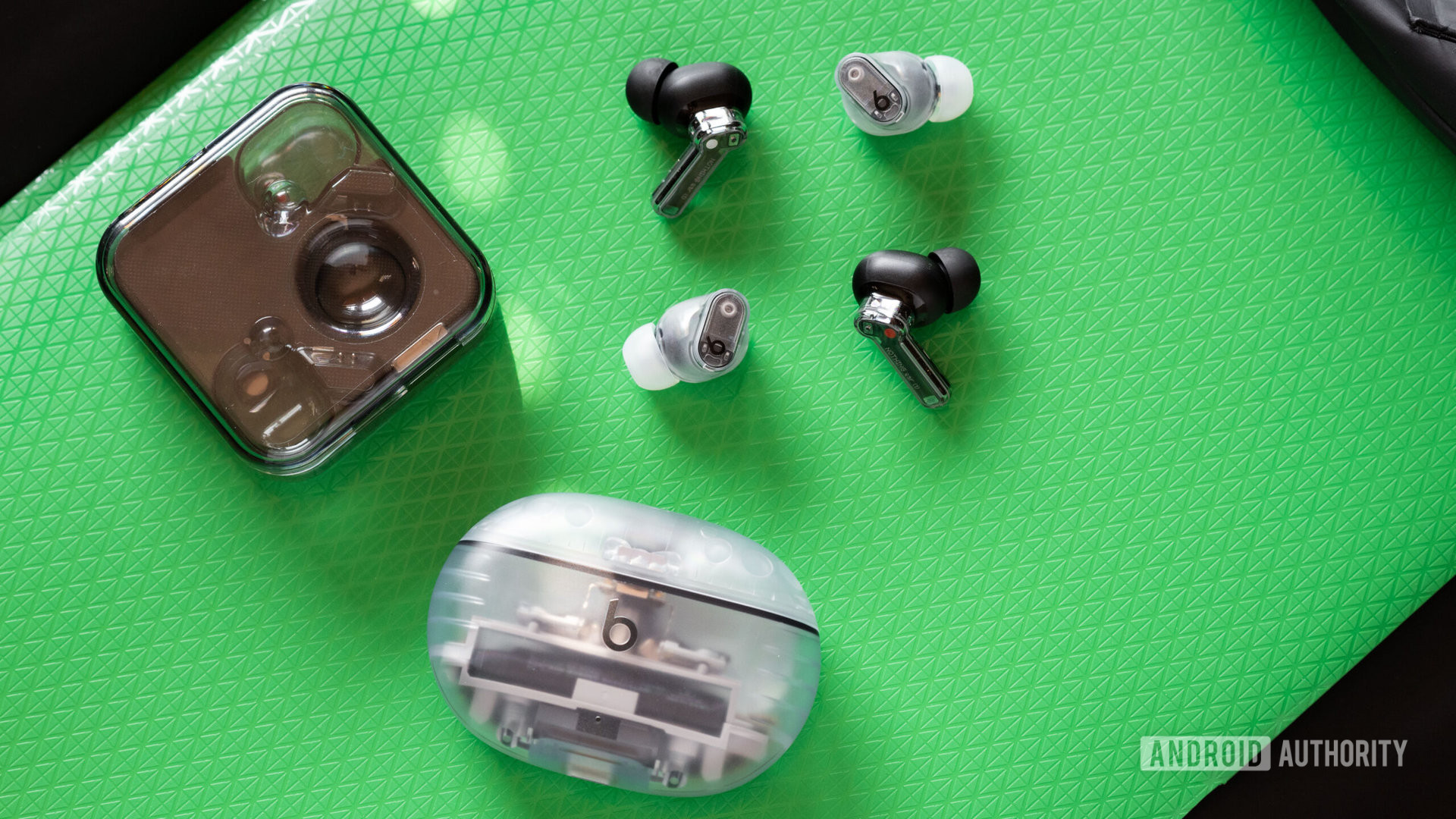 The Beats Studio Buds Plus and Nothing Ear 1 earbuds and cases for size comparisons.
