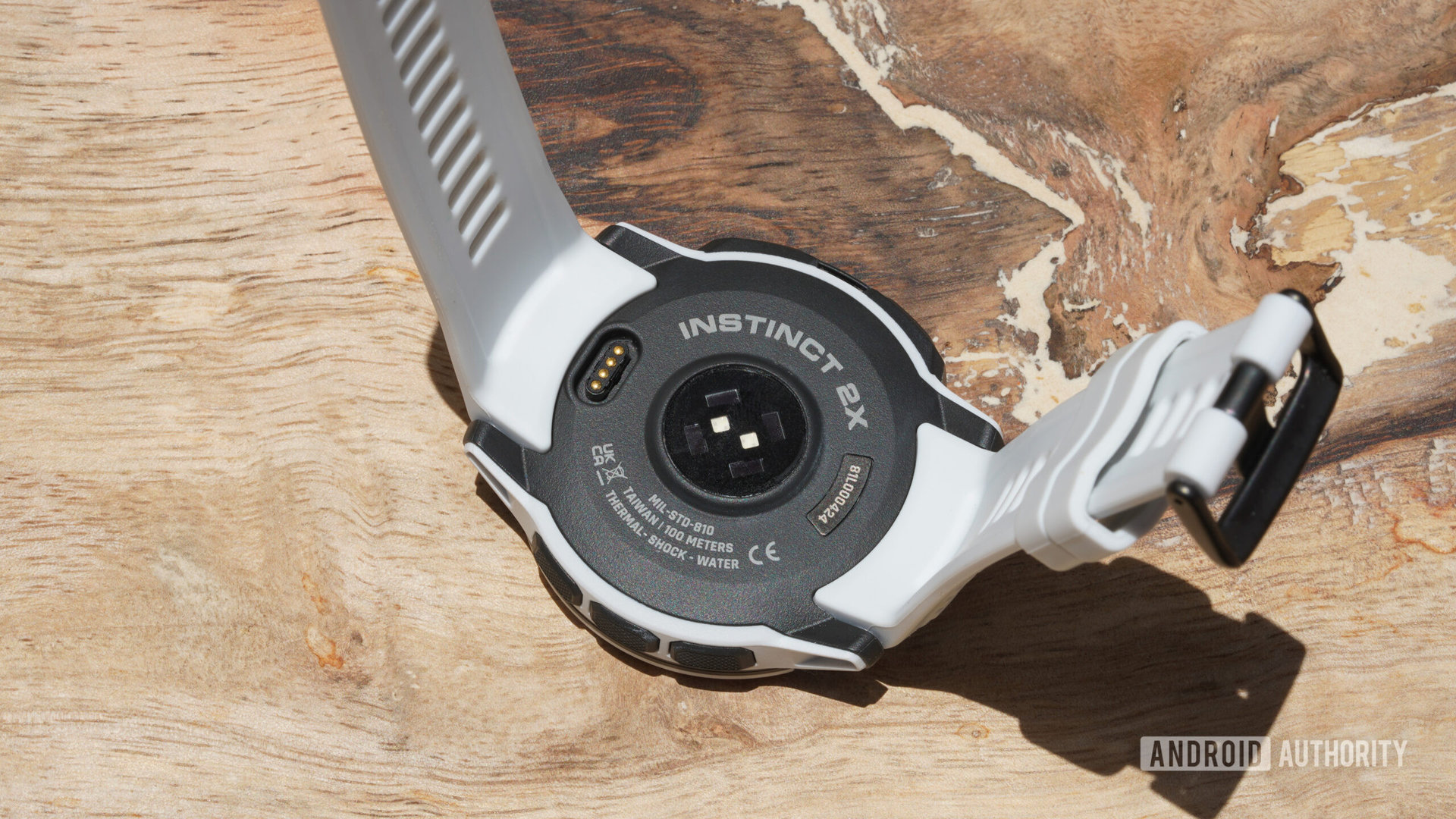 A Garmin Instinct 2X rests face down displaying its heart rate monitor.