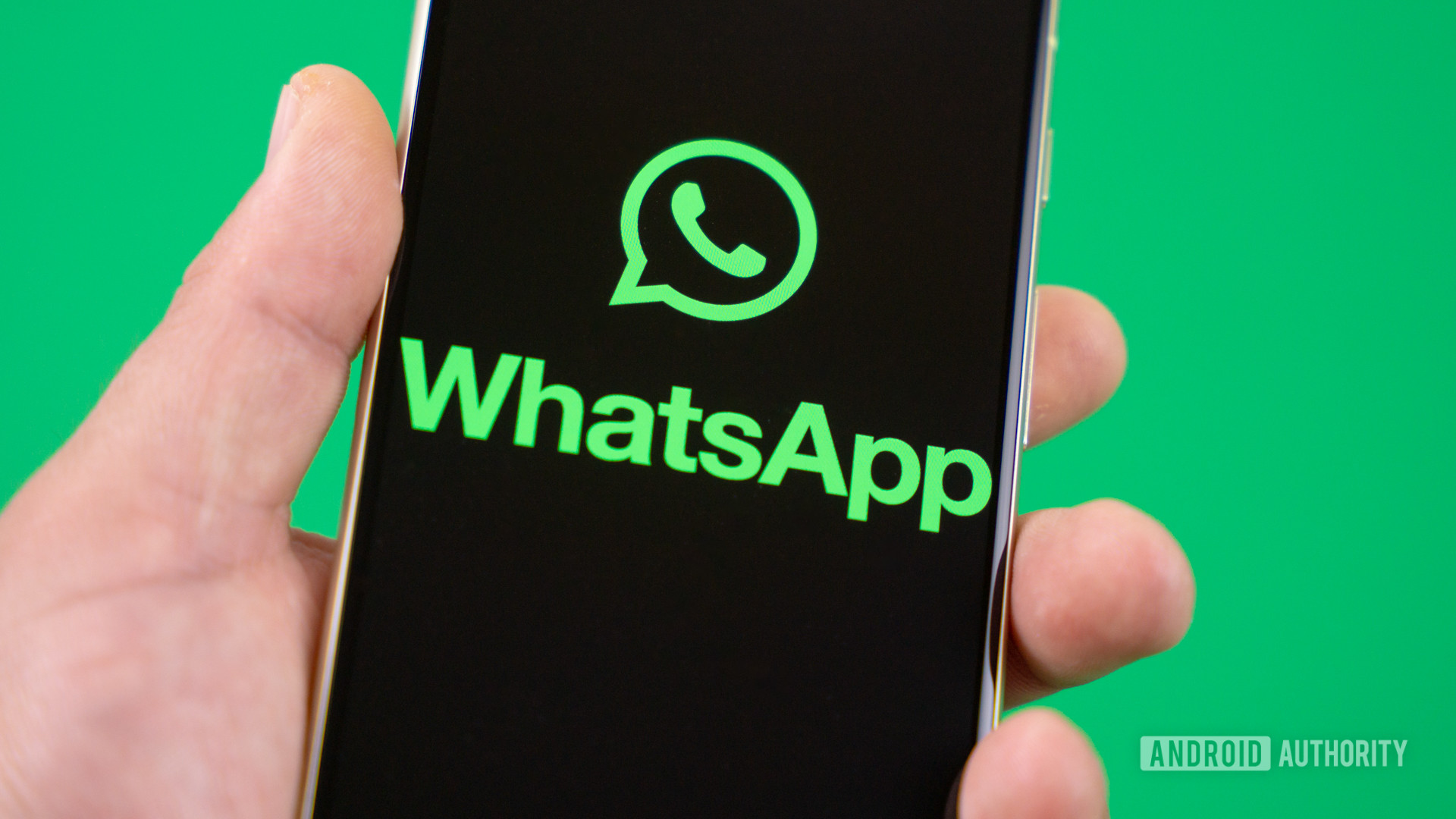 Holding smartphone with WhatsApp logo on the screen Stock photo