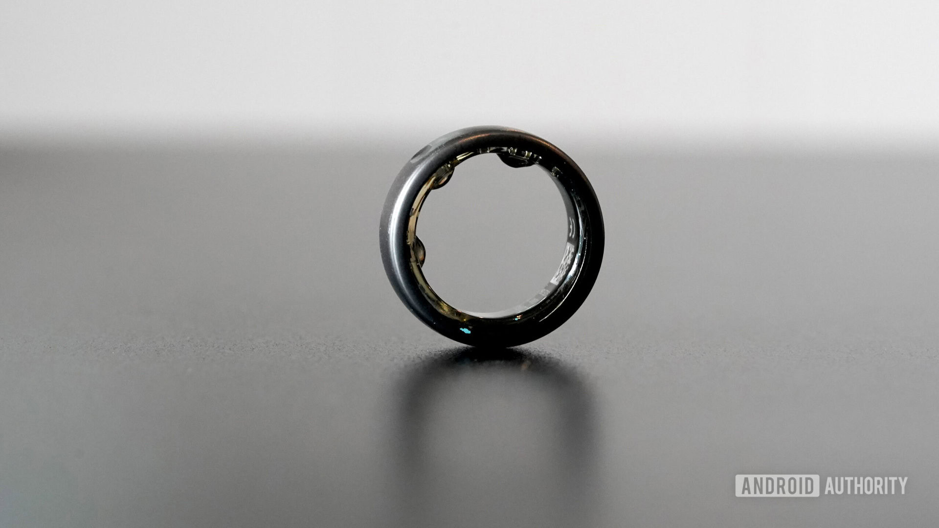 Oura dezenter Ring, der auf einer schwarzen Oberfläche ruht.