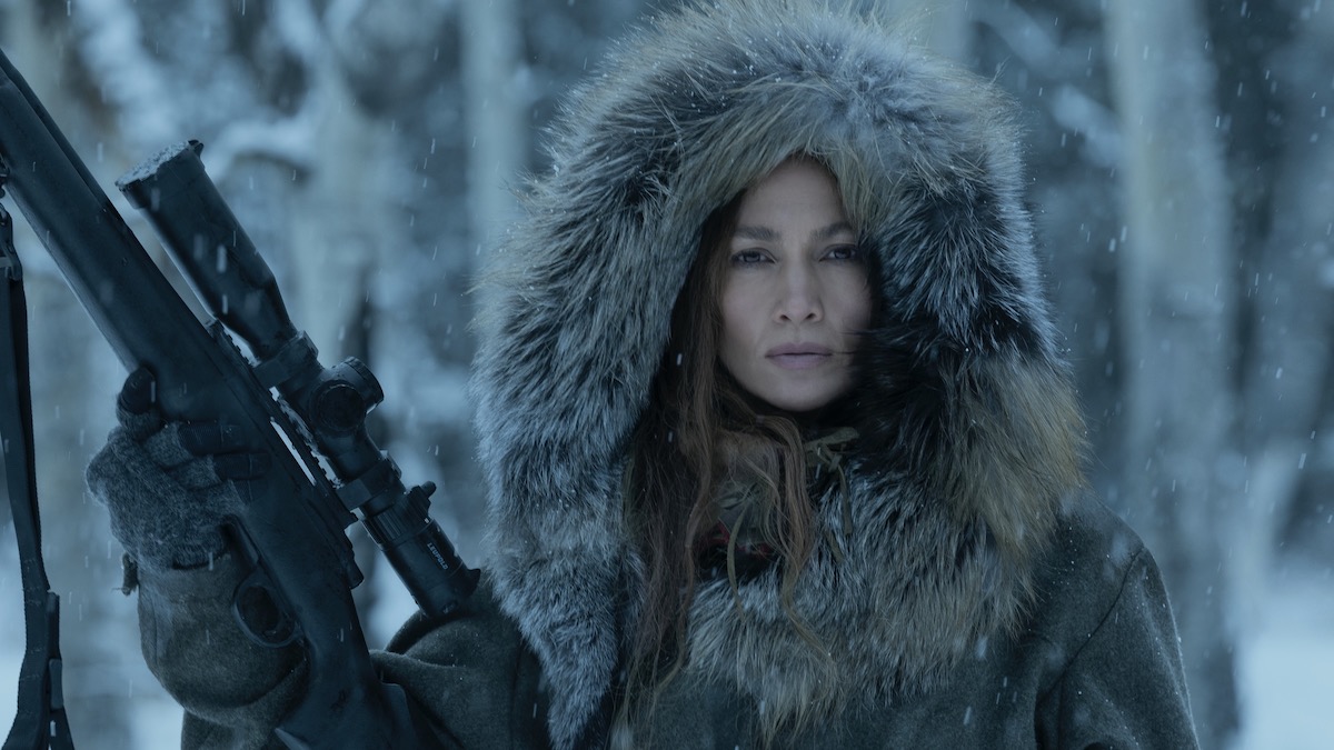 Jennifer Lopez in a snowy forest holding a rifle in The Mother
