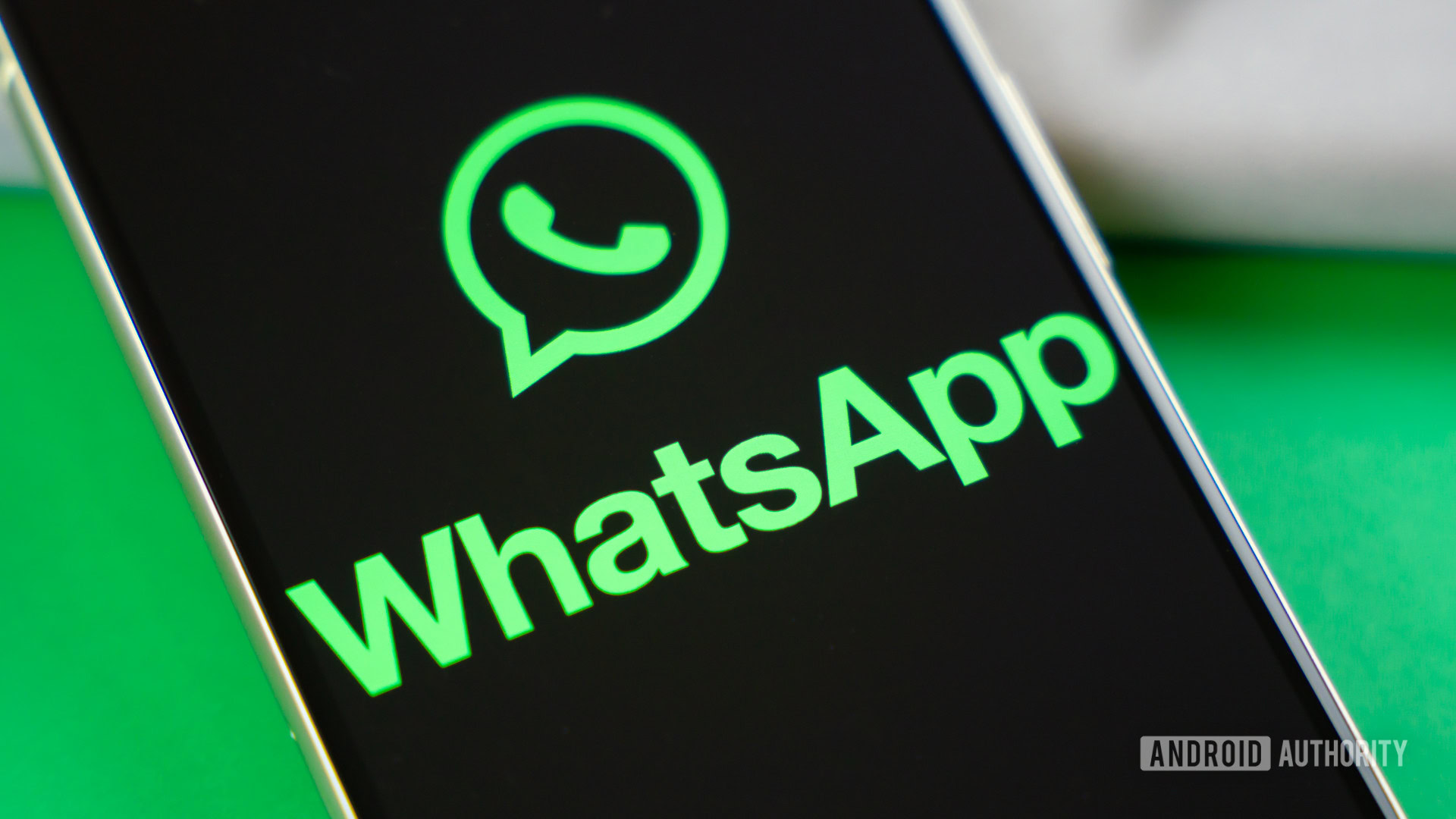 Logotipo de WhatsApp en el teléfono inteligente junto a los accesorios cotidianos Foto de stock 2