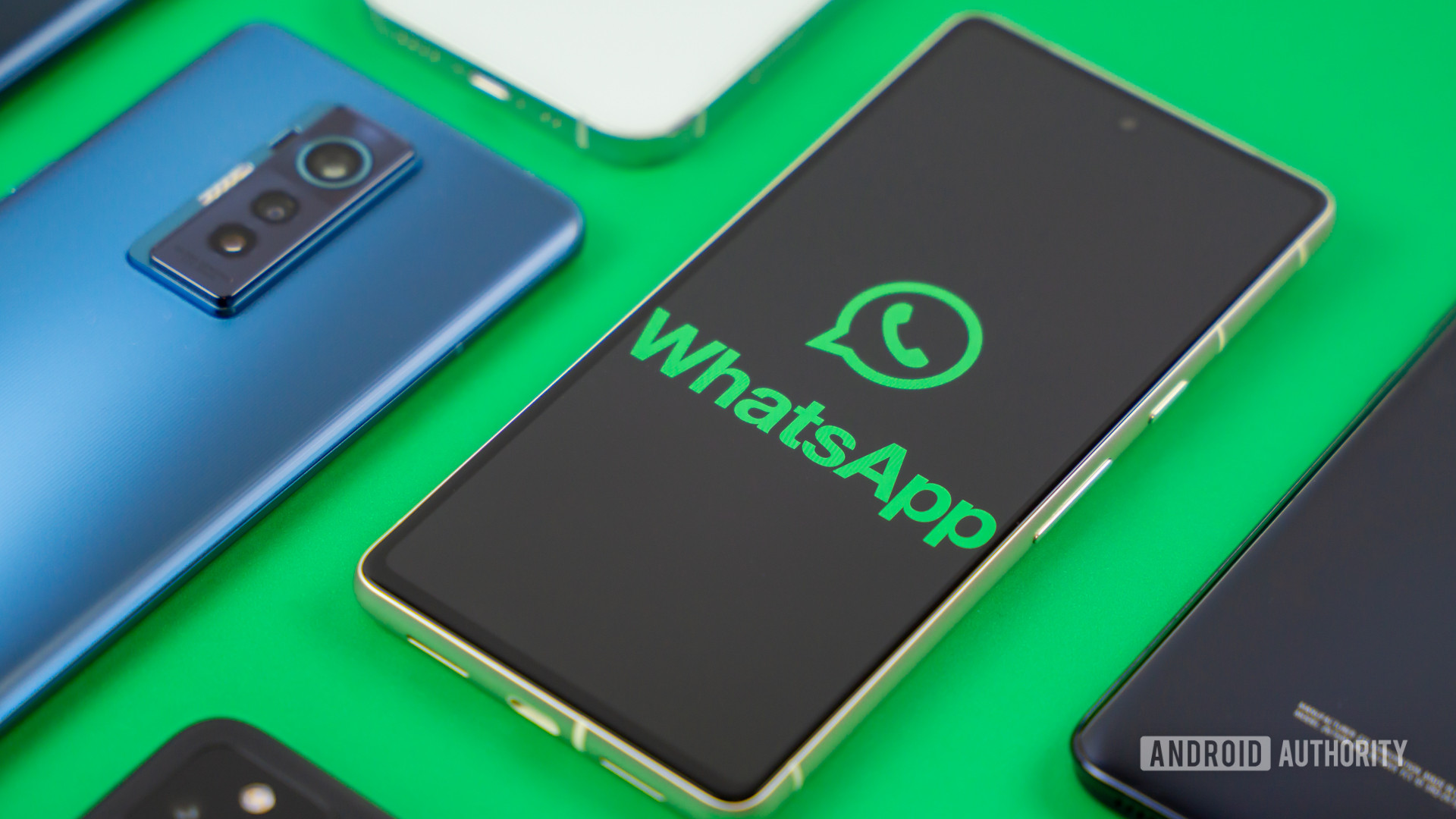 WhatsApp logo on smartphone next to other devices Stock photo 1