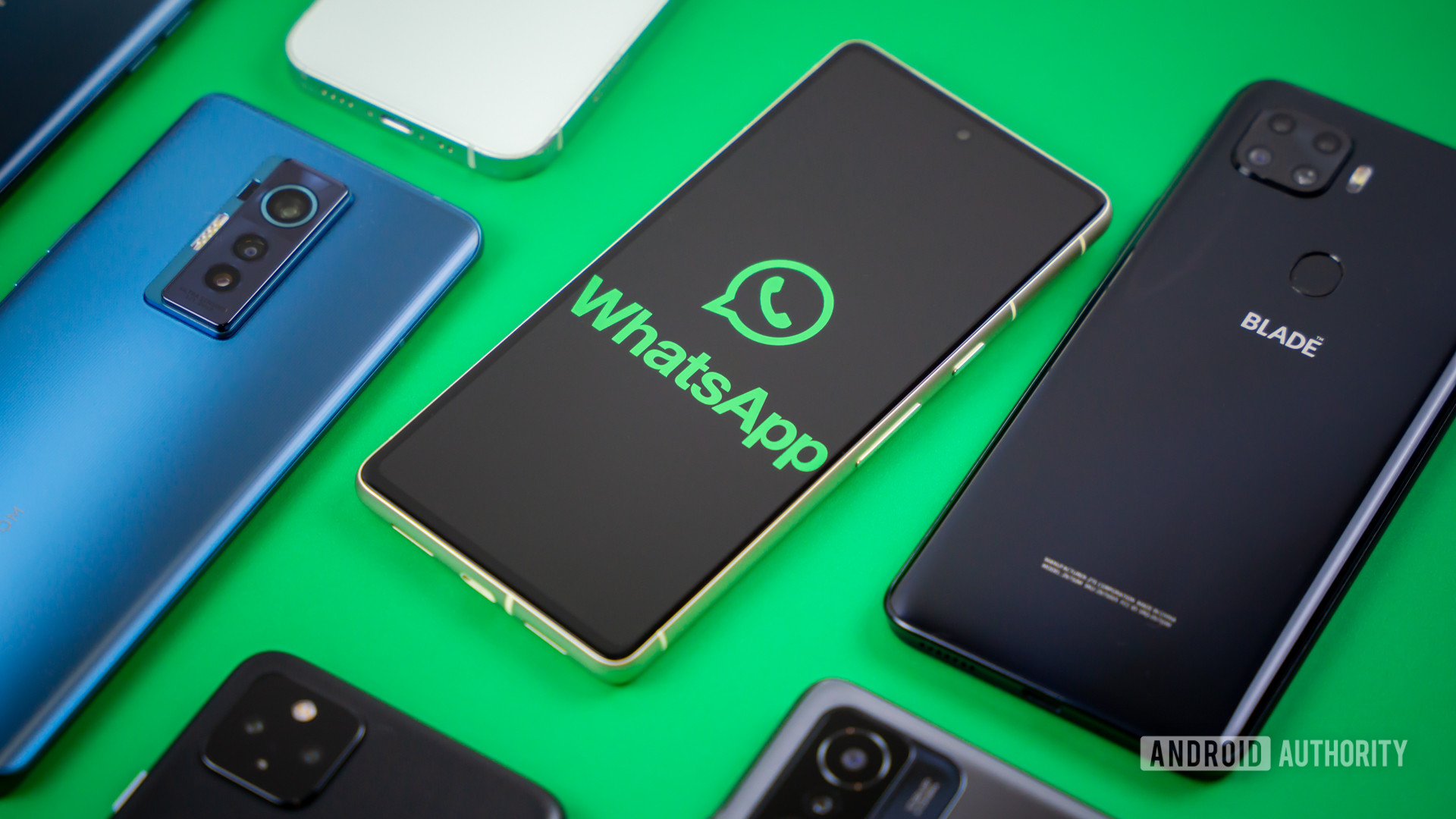 WhatsApp logo on smartphone next to other devices Stock photo 3