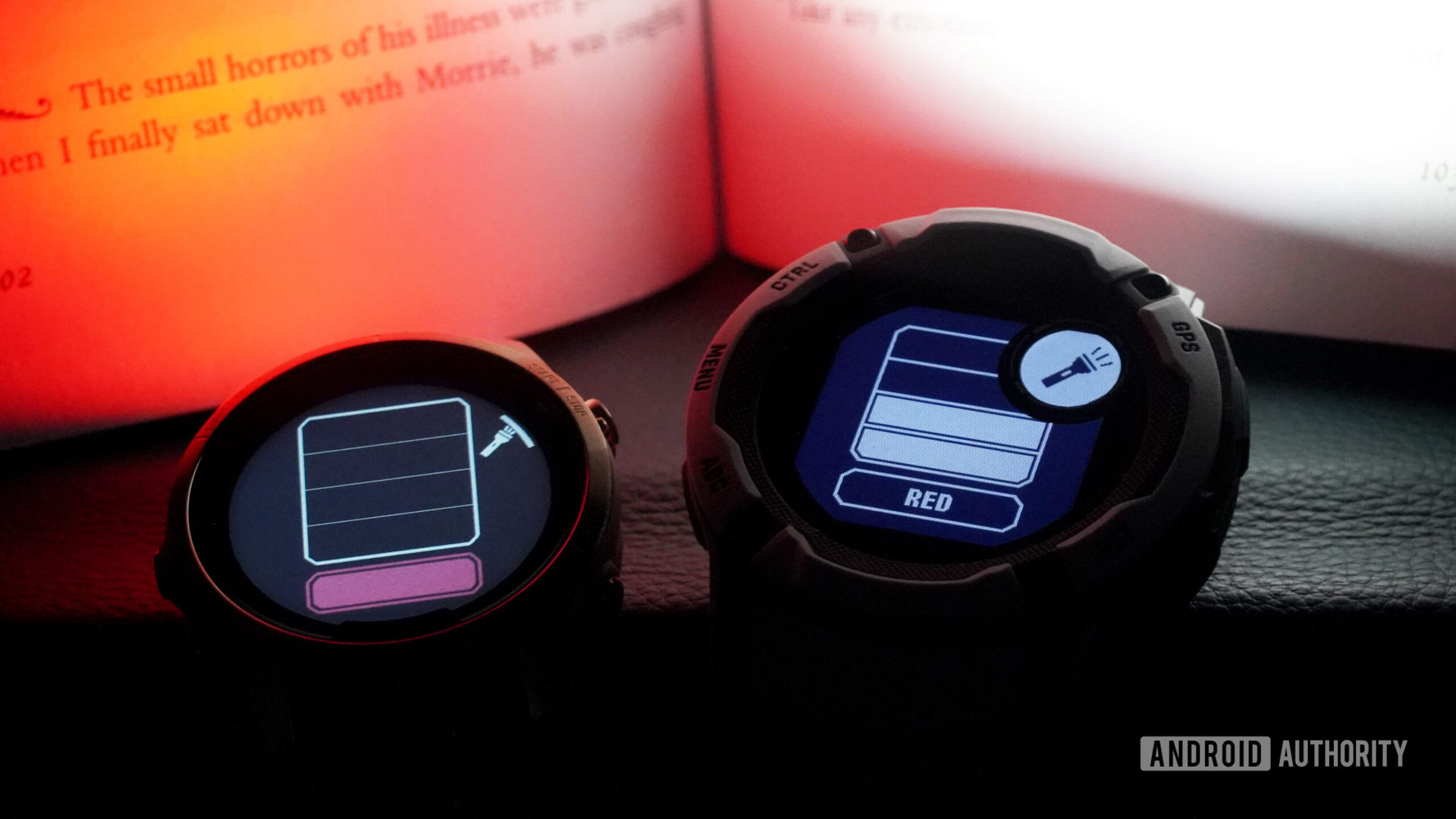 Two Garmin devices illuminate a book at night, one shining a white light and one in red mode.