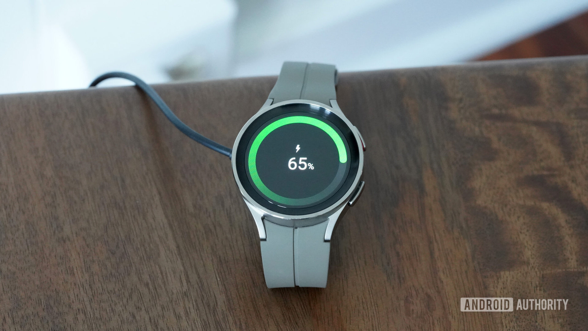 A Samsung Galaxy Watch 5 Pro rests on its charger.