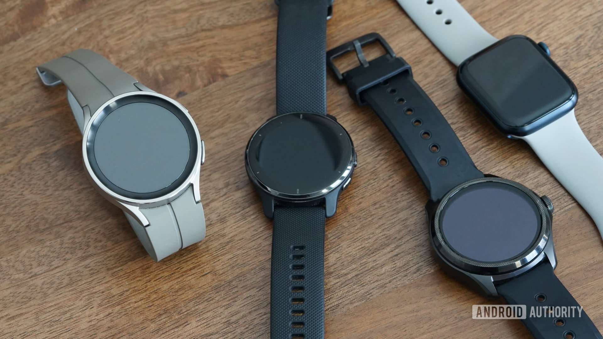 A Samsung Galaxy Watch 5 series devices rests alongside competitors from Garmin, Apple, and Mobvoi.