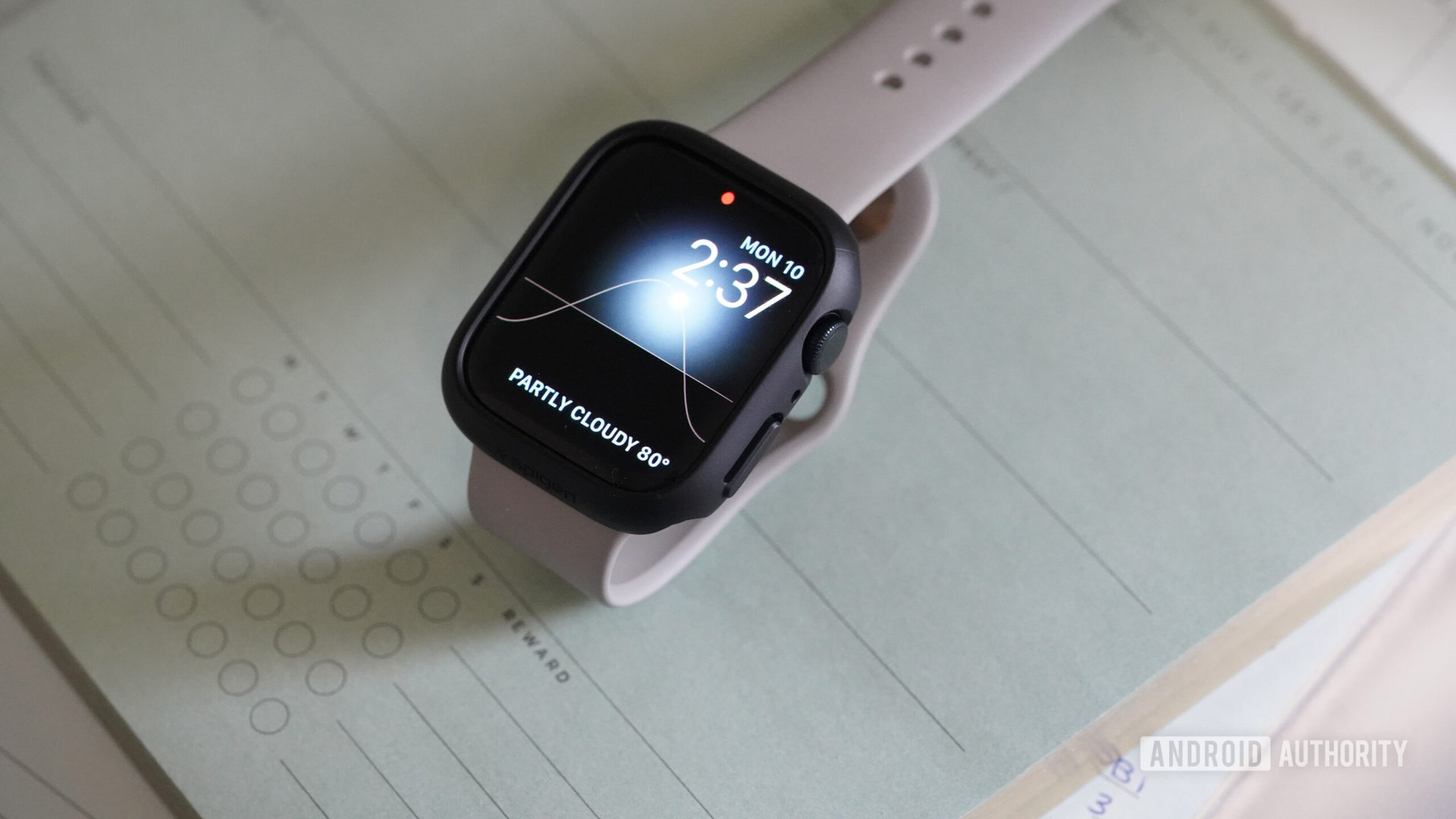 Un Apple Watch Series 8 con estuche Spigen Thin Fit descansa sobre el calendario de escritorio de un usuario.