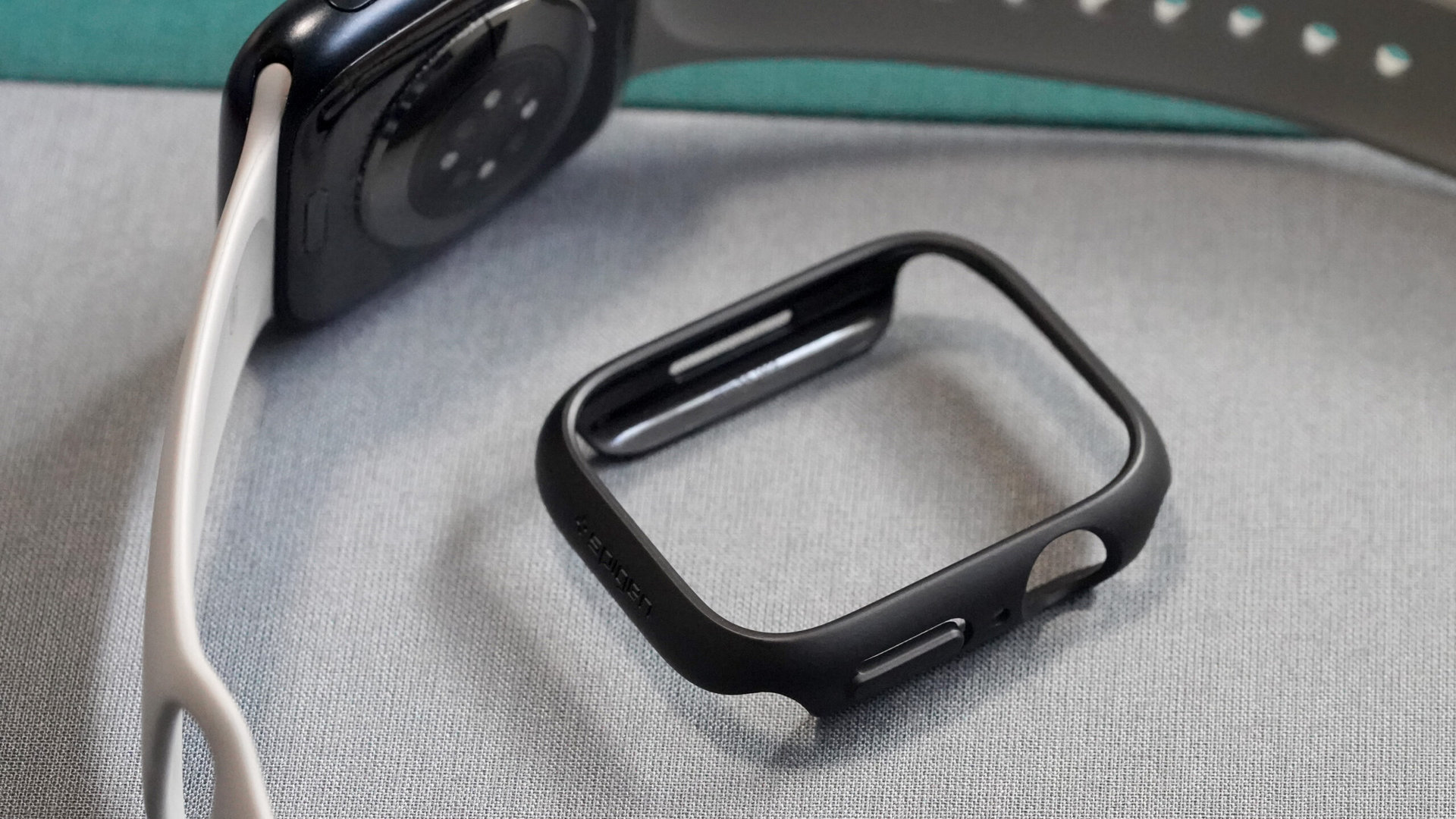Ein Spigen Thin Fit liegt neben einer Apple Watch Series 8.