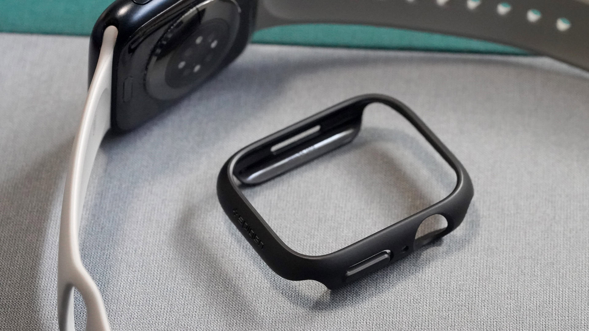 A Spigen Thin Fit rests alongside an Apple Watch Series 8.