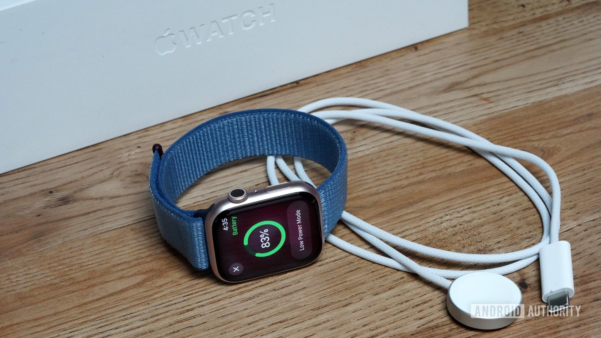 An Apple Watch Series 9 rests alongside its charger.