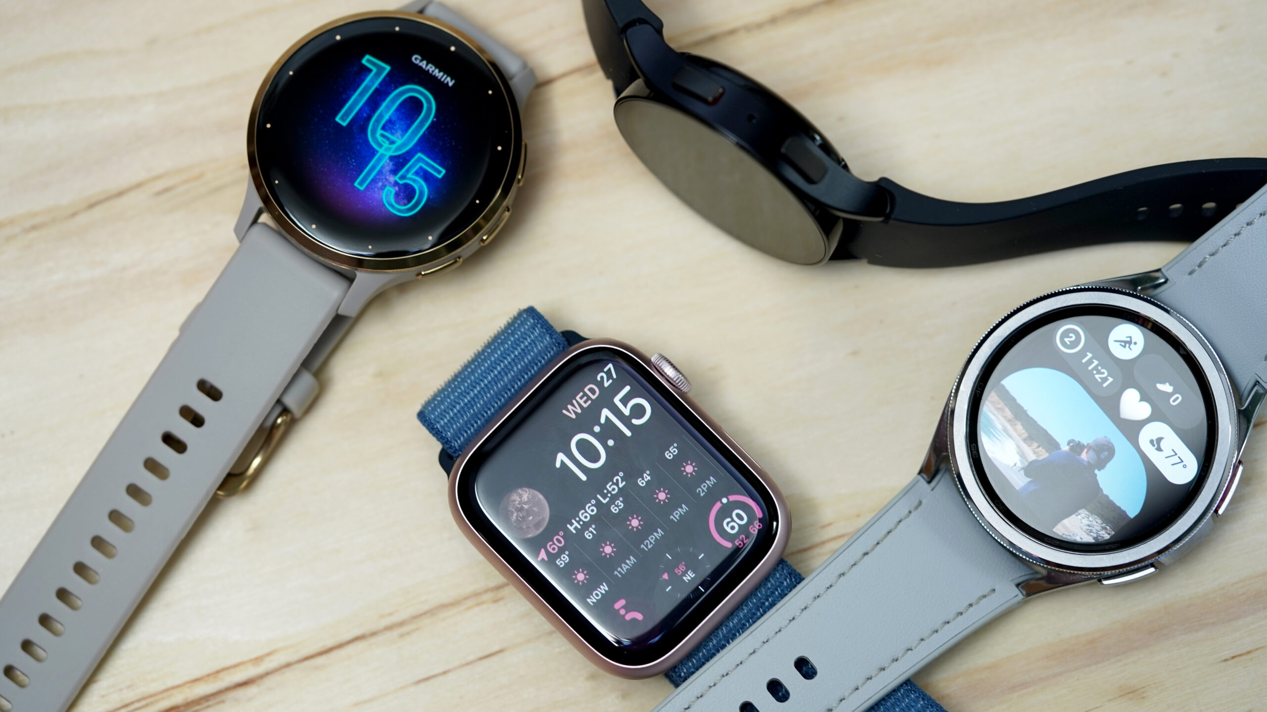 A variety of alternative smartwatches rest on a wooden surface.