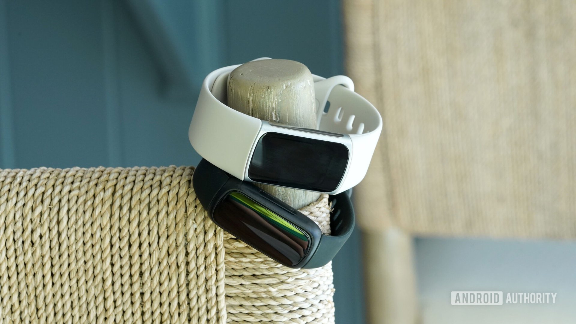 A Fitbit Charge 6 and Fitbit Inspire 3 hang from a bar stool.