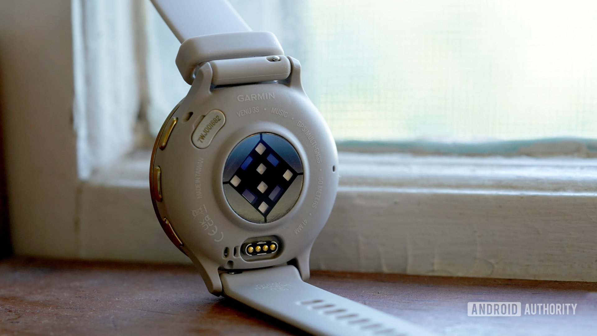 A Venu 3 rests face down displaying its heart rate sensor.