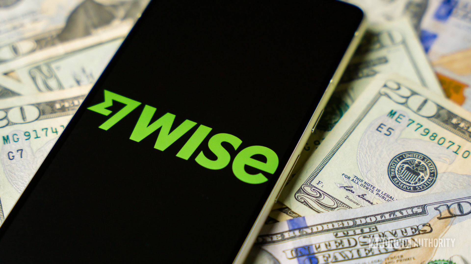 Wise logo on smartphone with cash on background stock photo (4)