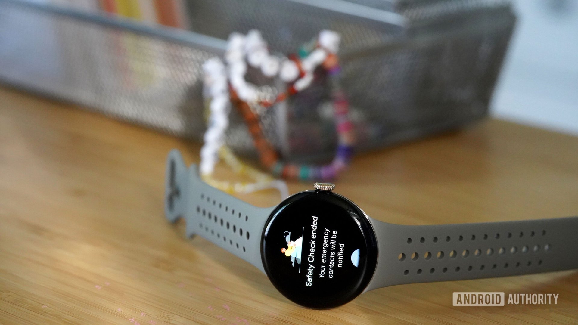 A Pixel Watch 2 rests on a teen's desk, display Safety Check.