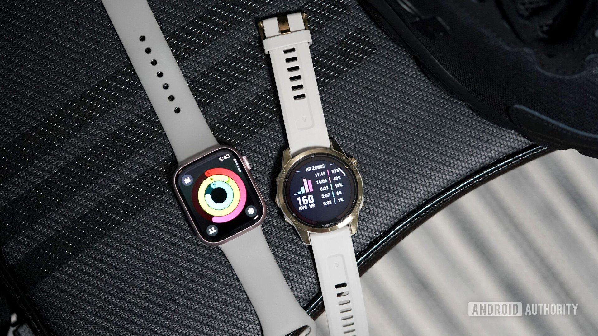 An Apple Watch Series 9 rests alongside a Garmin Fenix 7 Pro, each displaying fitness related screens.