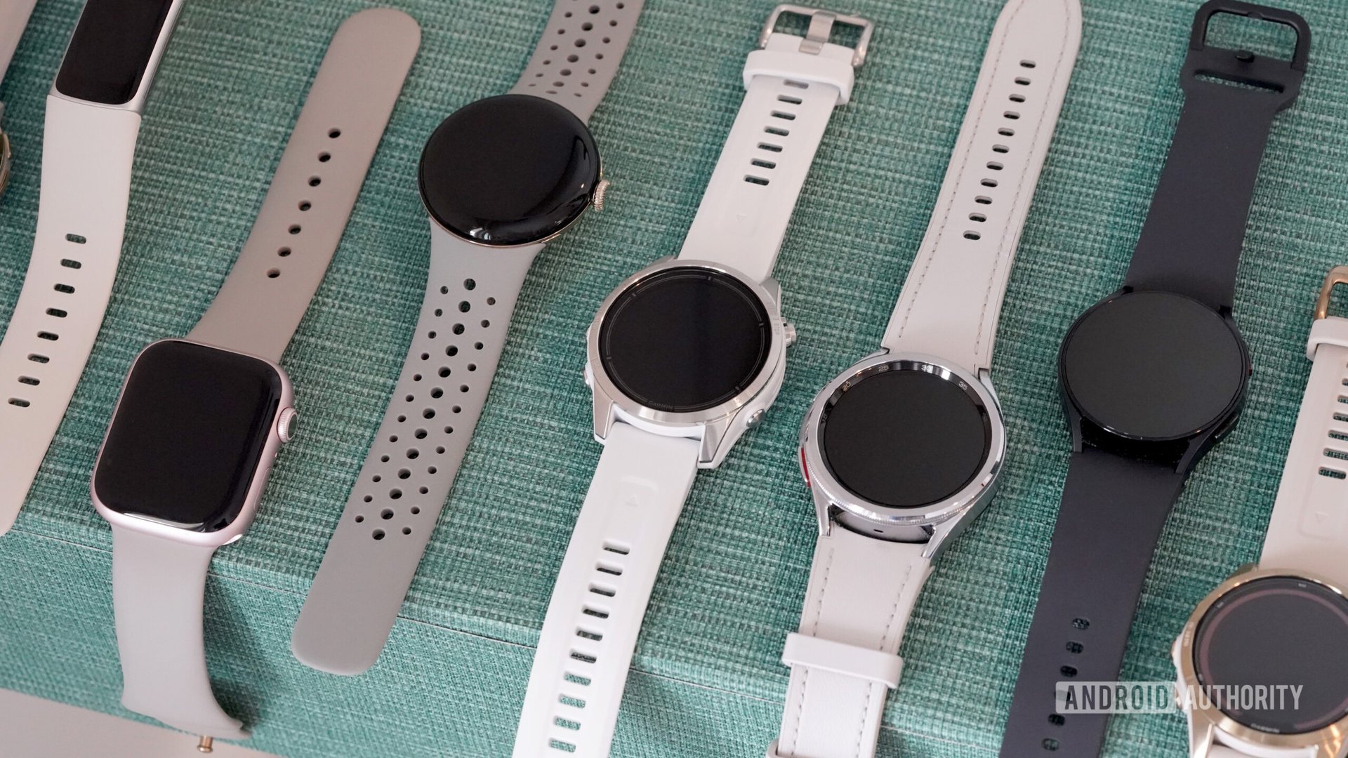 A variety of the best wearables of 2023 rest on a green surface.