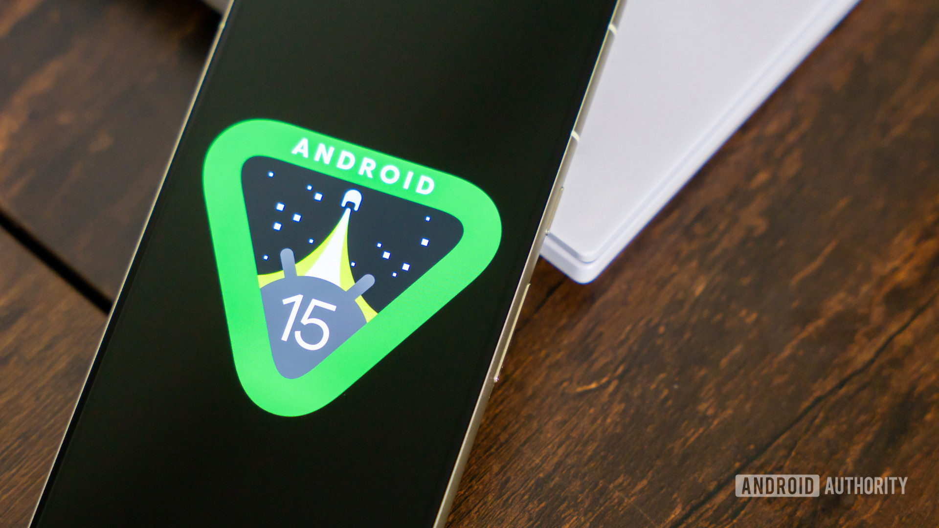 Android 15 logo on smartphone on coffee table stock photo (6)