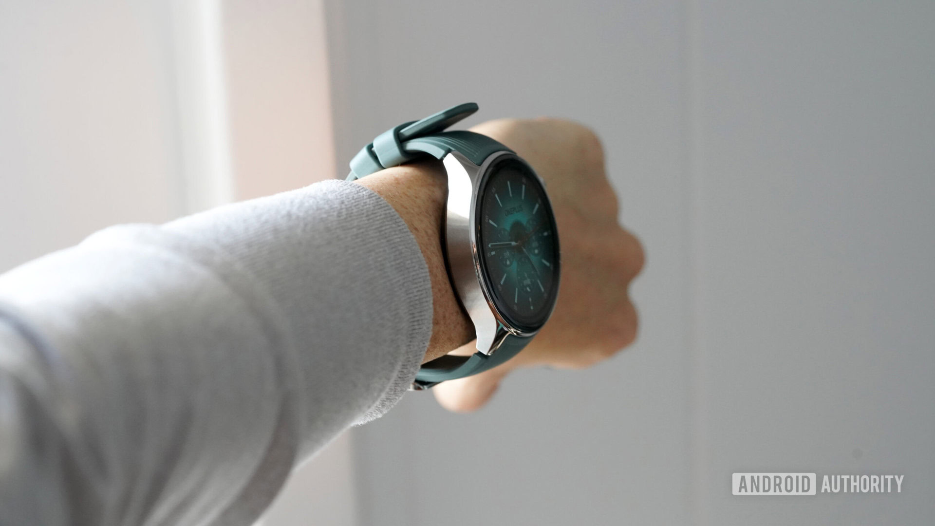 A user wears a OnePlus Watch 2 on their wrist, modeling the device's large lugs and gaping band design.