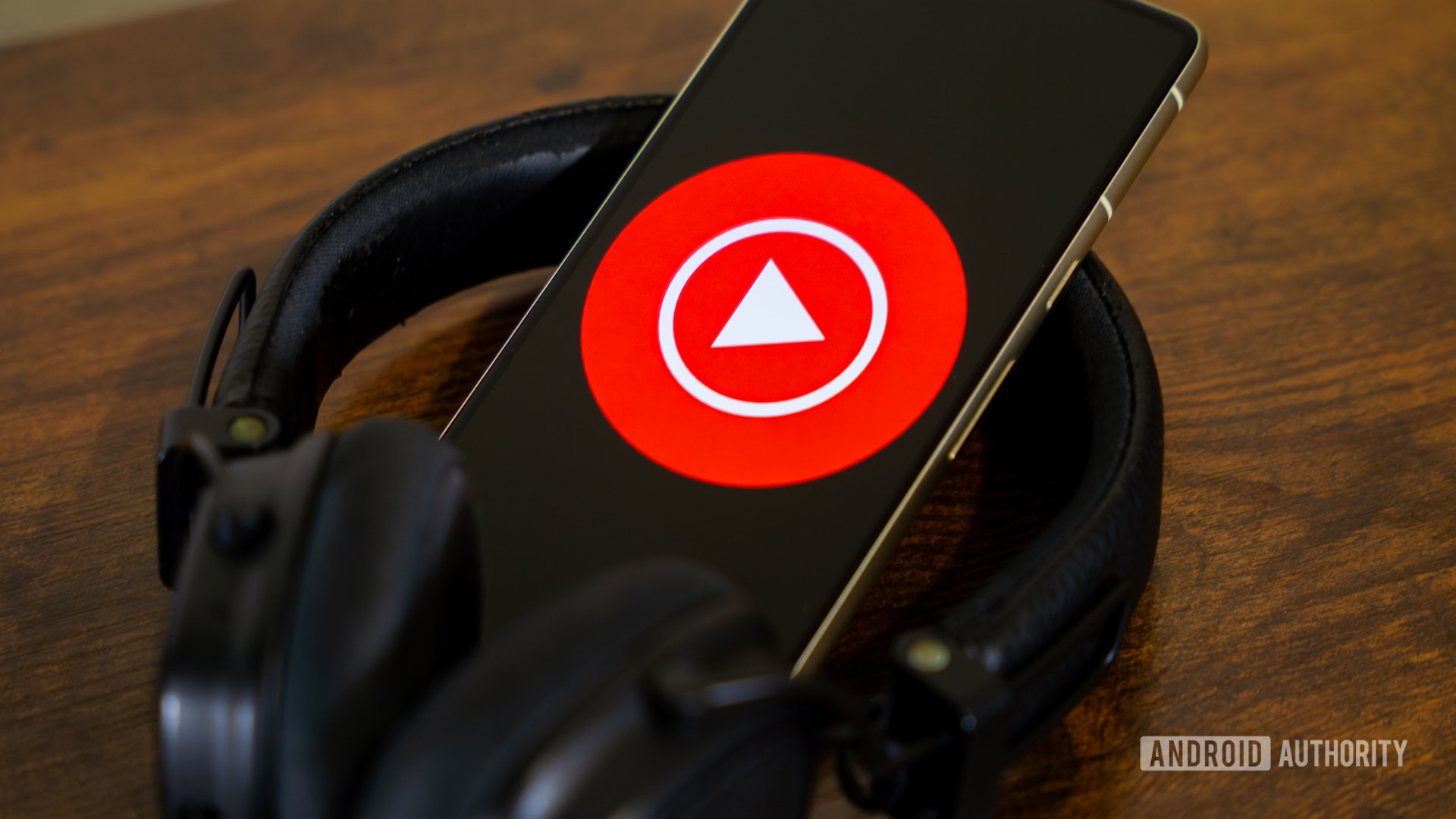 YouTube Music logo on smartphone with headphones