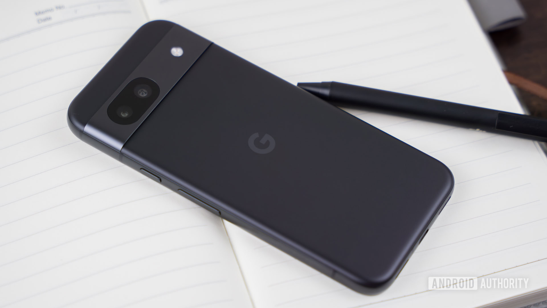 Google Pixel 8a laying on top of notebook stock photo (3)