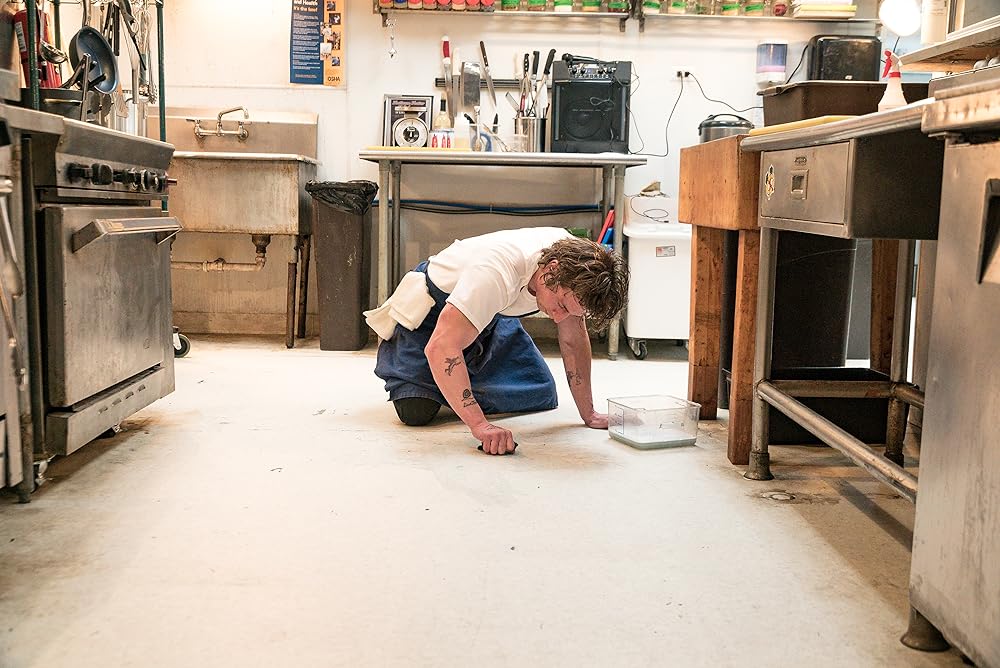 Carmy (Jeremy Allen White) scrubs the floor