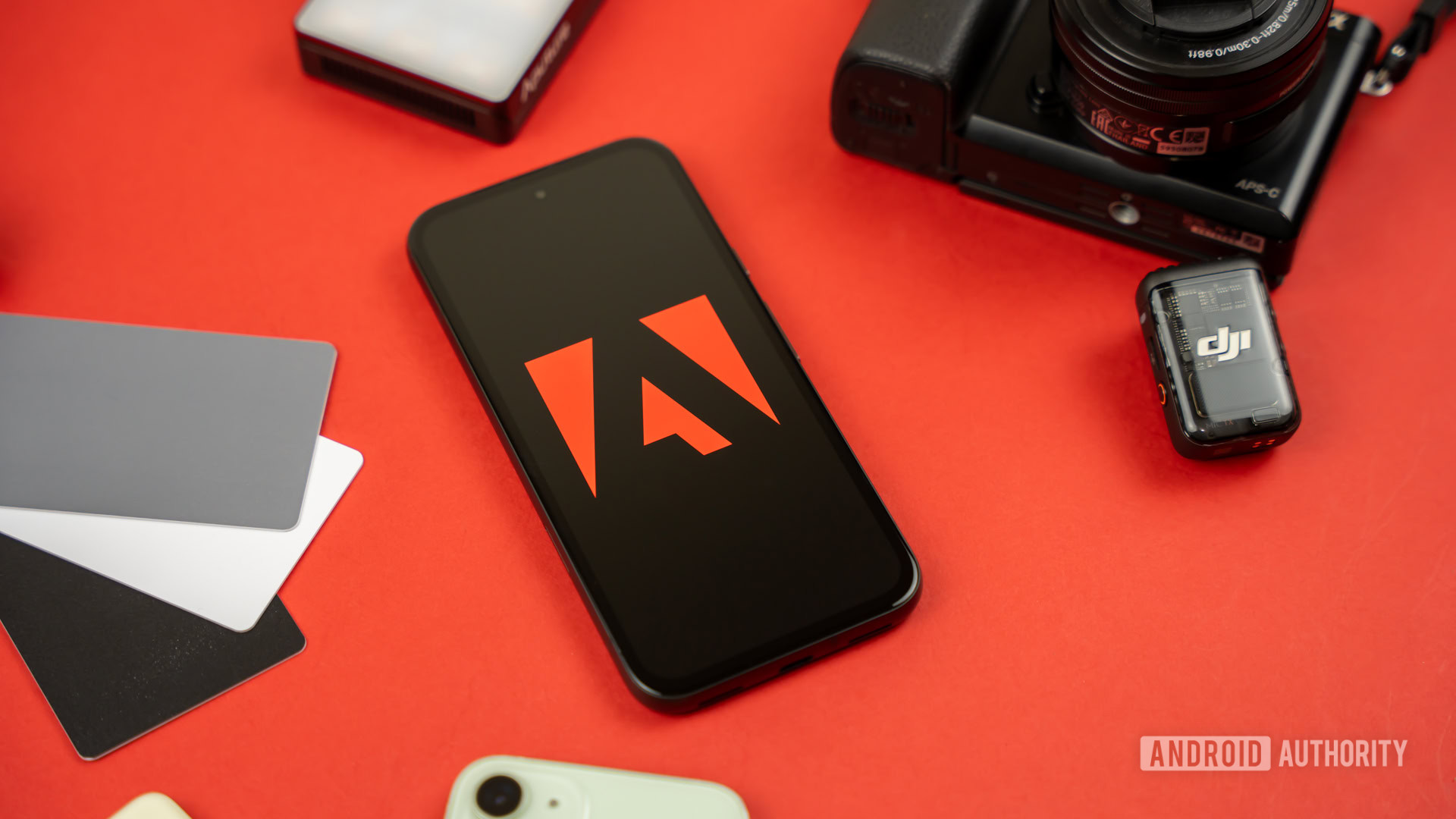 Adobe logo on smartphone, next to photography and videography products stock photo (3) Adobe logo on smartphone, next to photography and videography products stock photo (3)