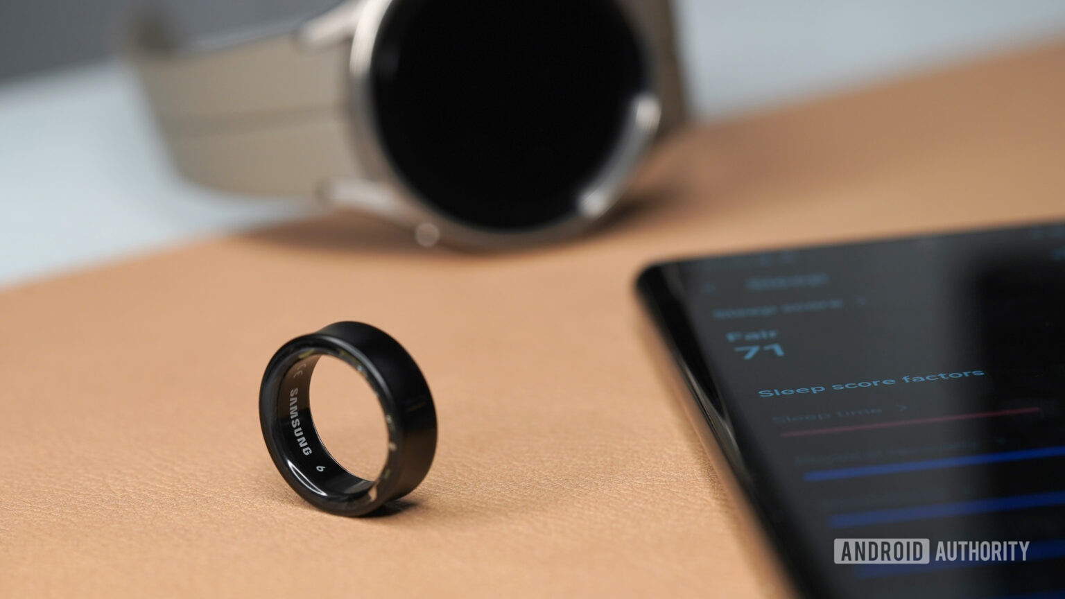 Samsung Galaxy Ring Sleep factors A Samsung Galaxy Ring rests alongside a Galaxy phone displaying sleep factors and a Galaxy Watch 5 Pro. factors