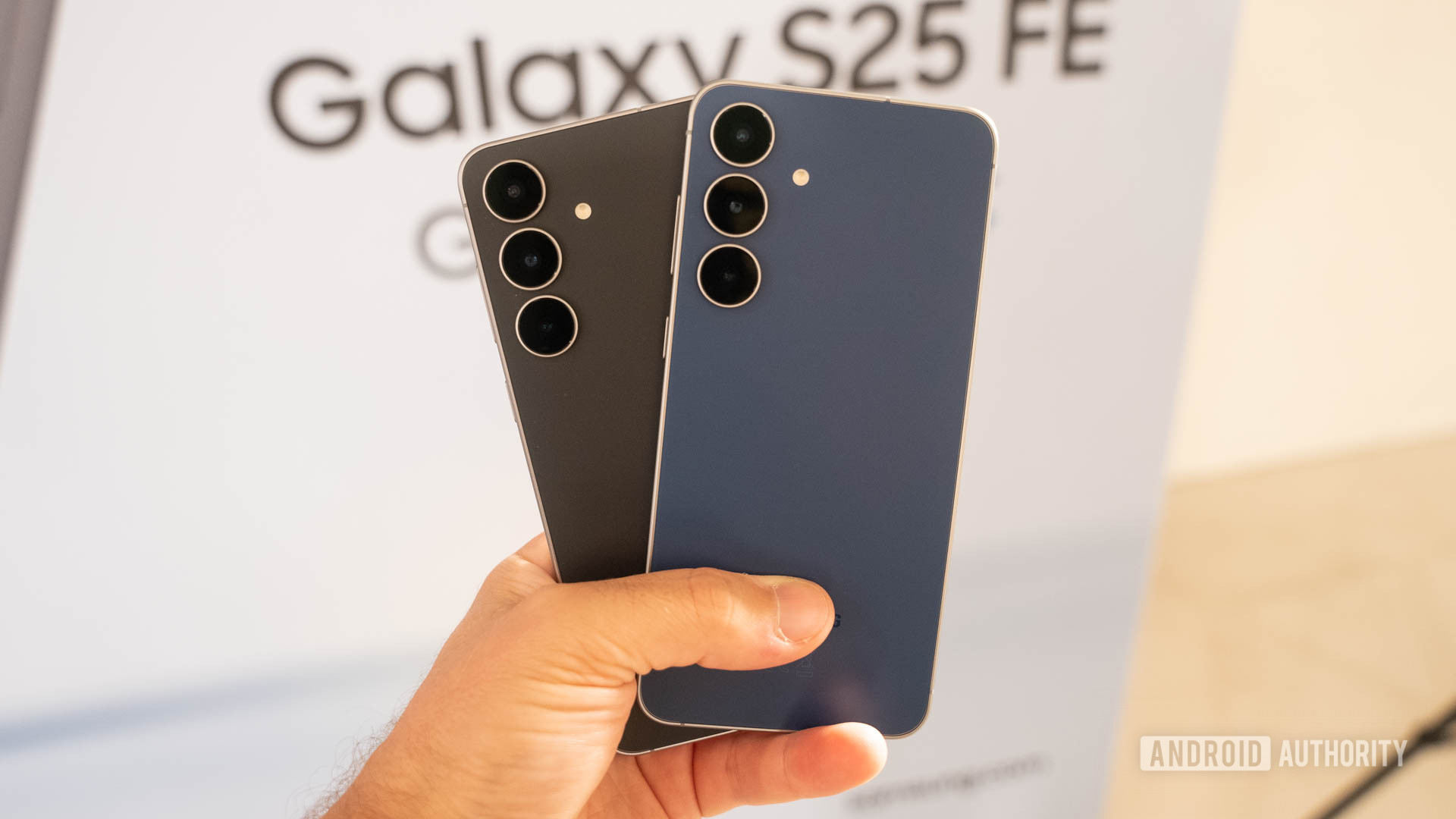 Samsung Galaxy S25 FE in Jetblack and Navy held together in man's hand Samsung Galaxy S25 FE in Jetblack and Navy held together in man's hand