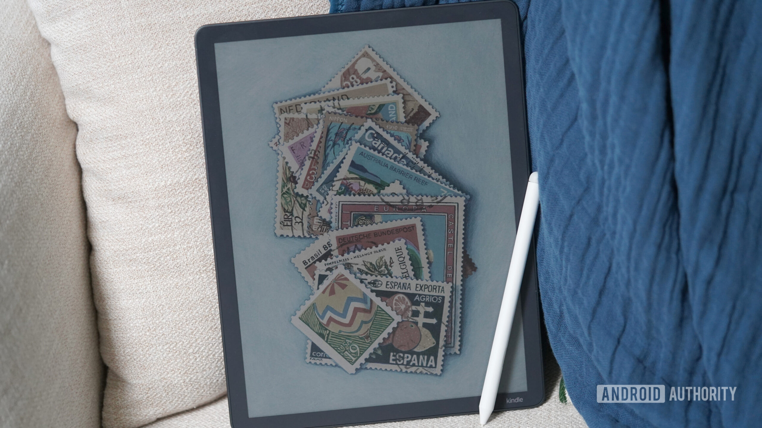 A Kindle Scribe Colorsoft rests on a couch.