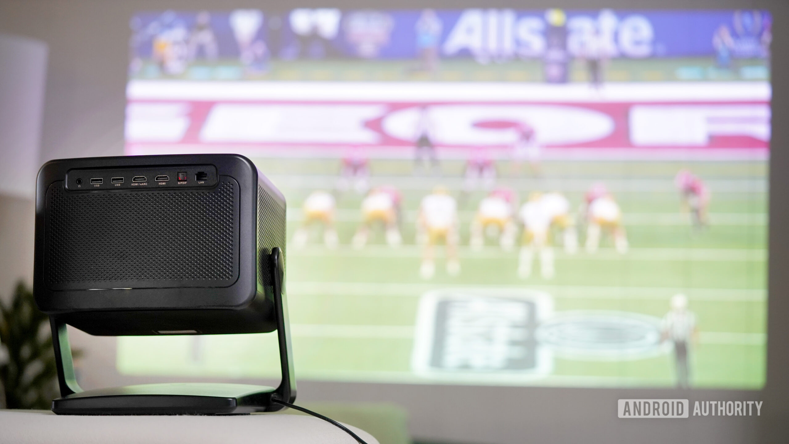 Portable Projector Sports A Dangbei DBOX02 Pro projects a college football game.