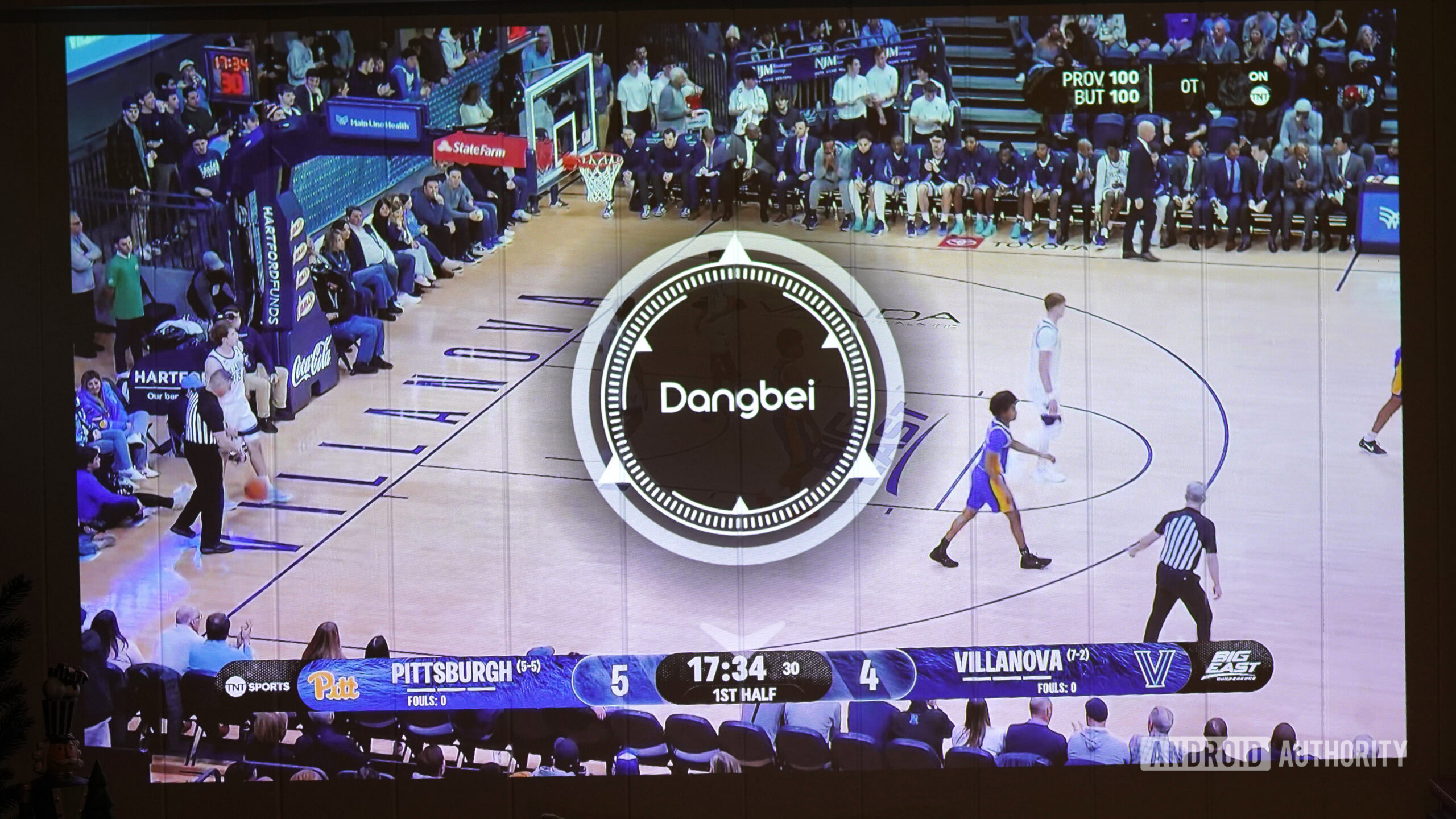 A user manually adjust their projectors focus during a basketball game.