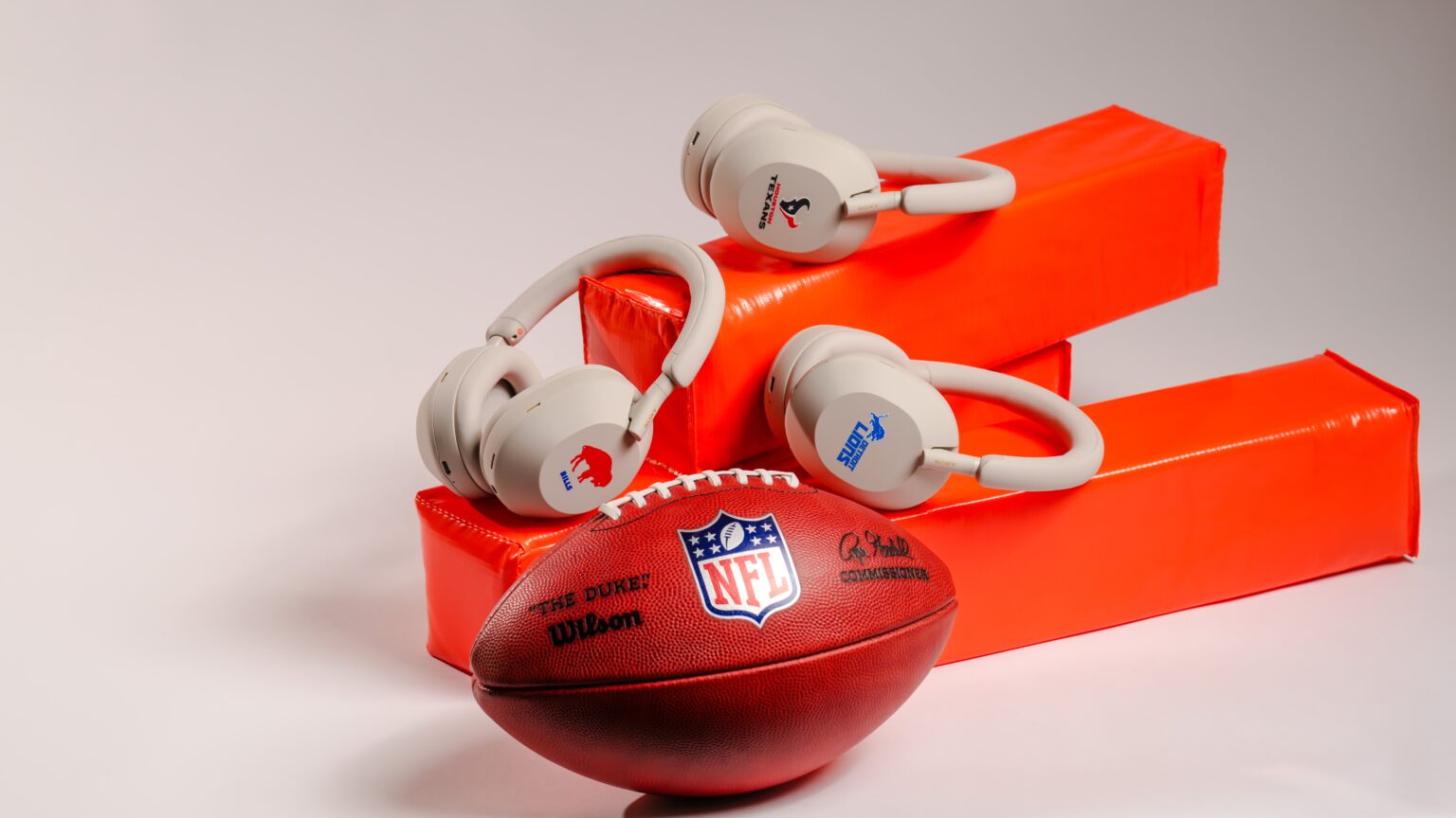 Sony WH-1000XM5 NFL headphones and football resting on a red wooden box