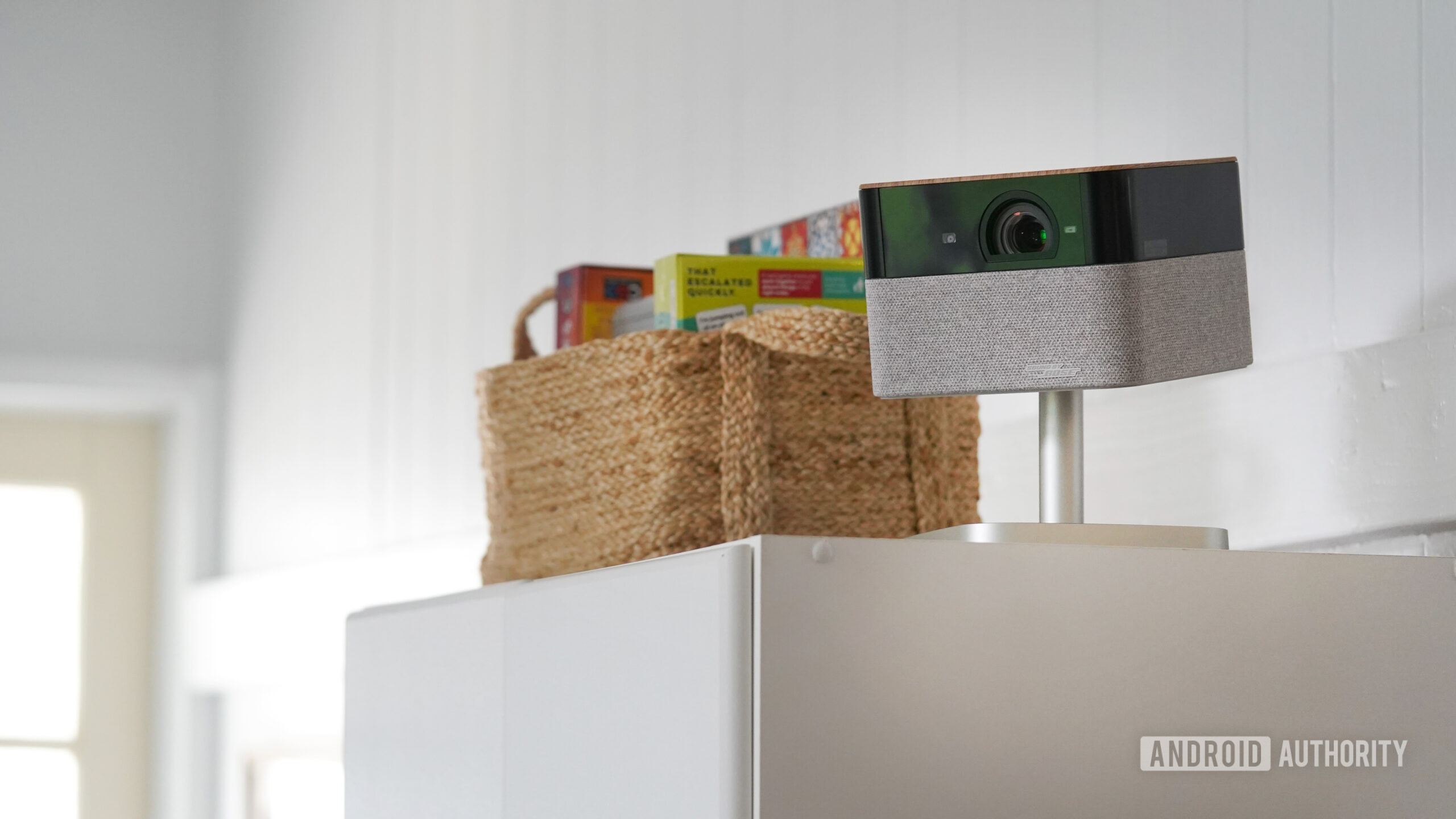A portable projector is stowed on a high shelf.