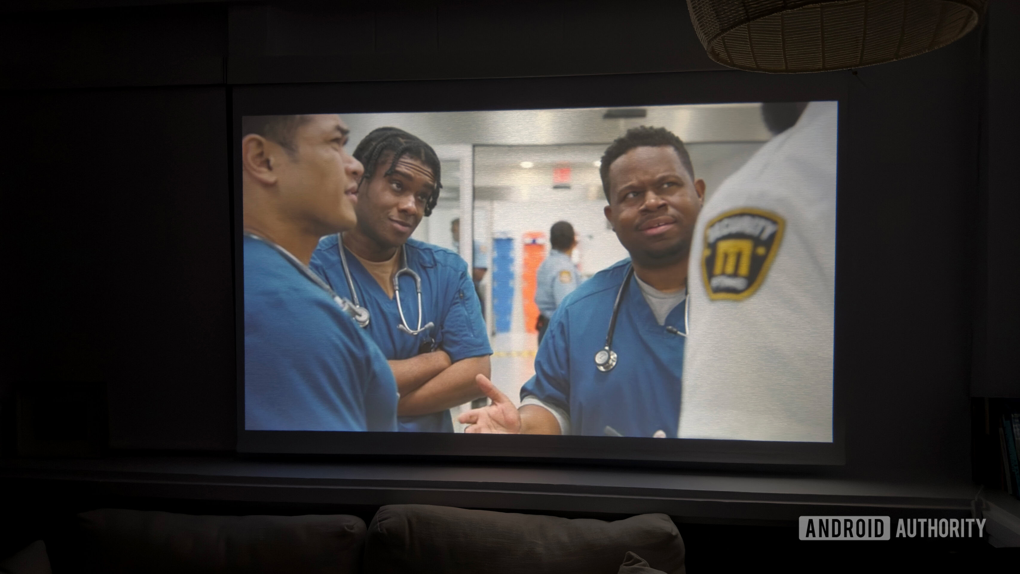 An Aurzen Roku TV EAZZE D1R projects a scene from The Pitt.