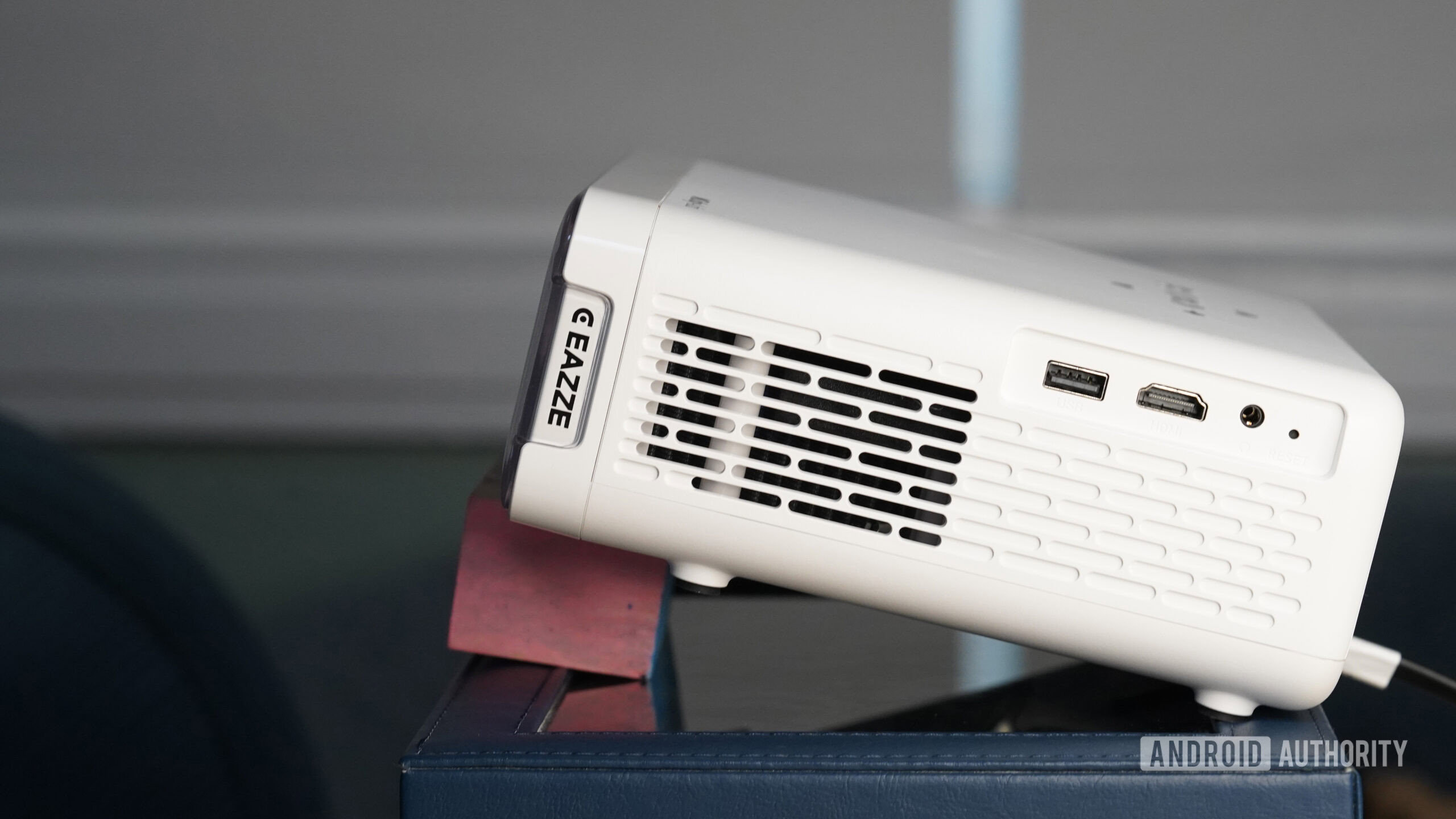 An Aurzen Roku TV EAZZE D1R is tilted with a wood block.